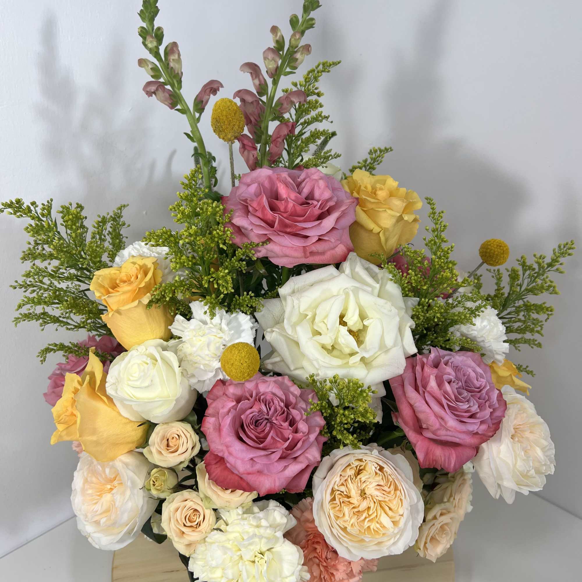 A romantic garden-style arrangement designed in an elegant white ceramic vase featuring