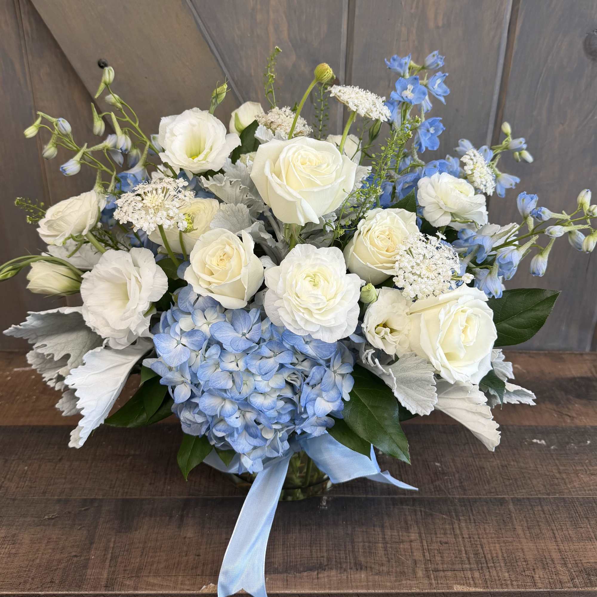 Coastal Elegance brings together premium white roses, lisianthus, ranunculus, and airy textural