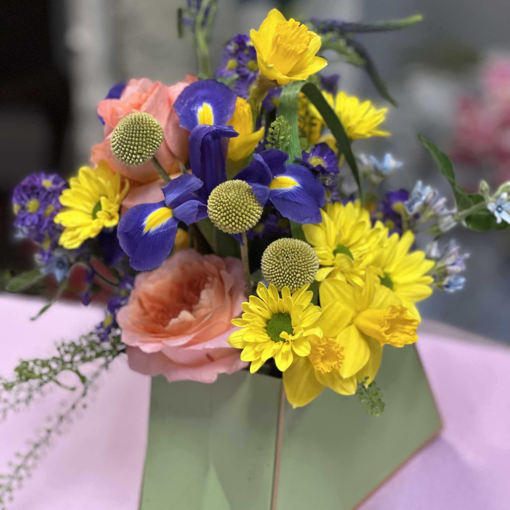 Bright bursts of yellow daisies and deep purple iris pop against soft