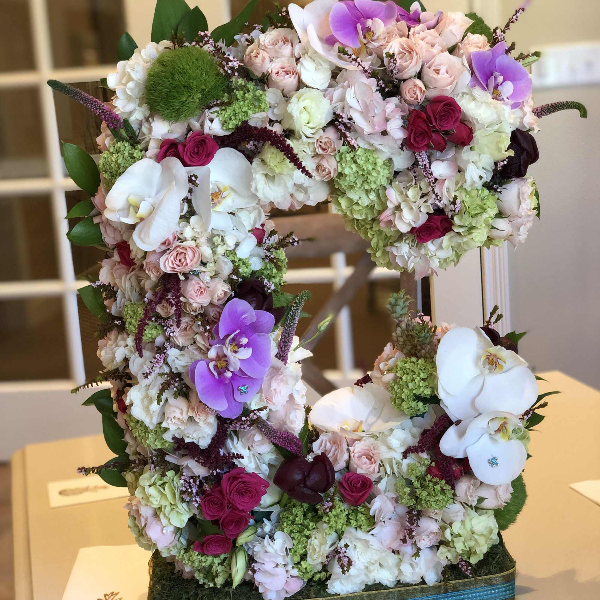 Large floral number sculpture covered in pink, white, and purple blooms