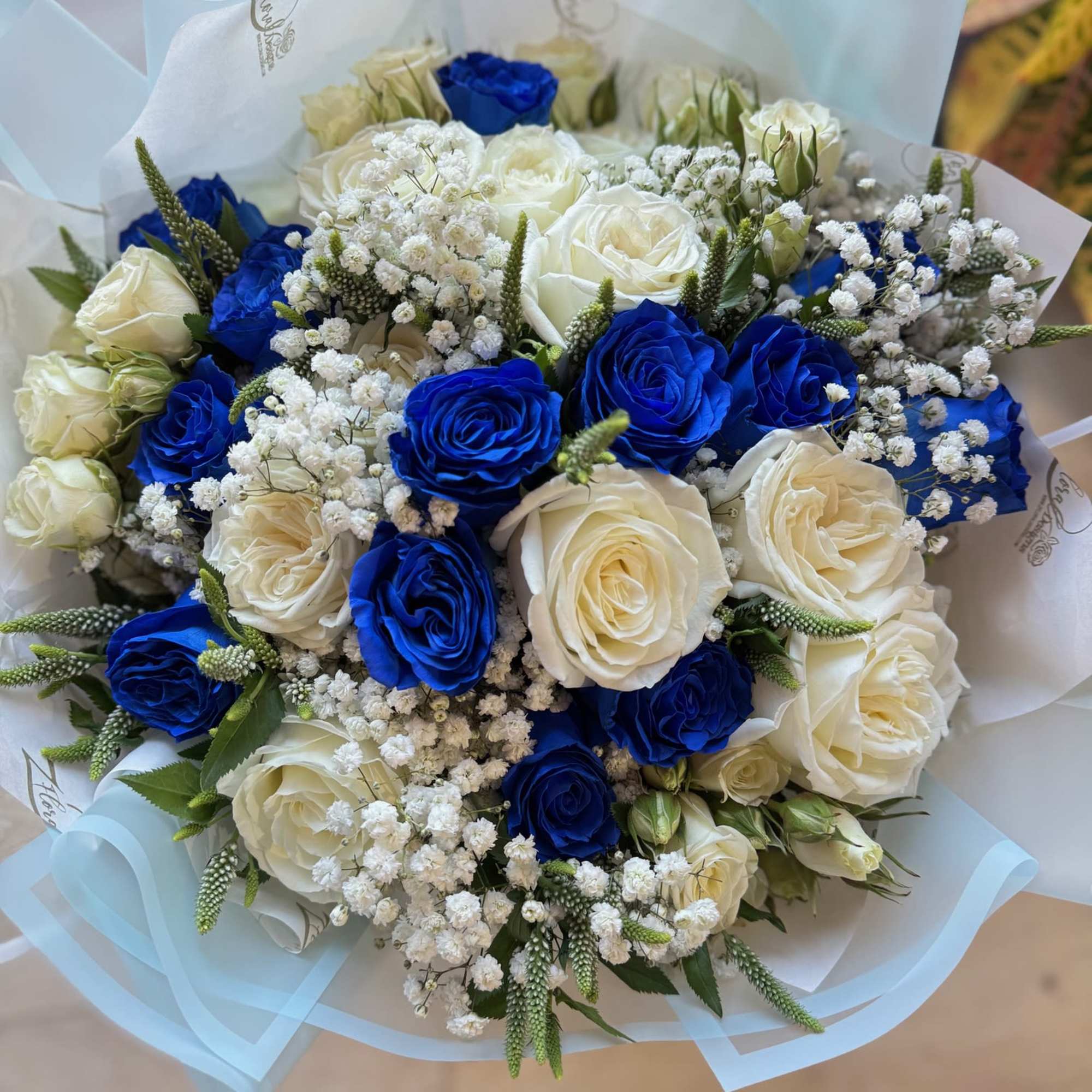 Bouquet of white and vivid blue roses with baby's breath