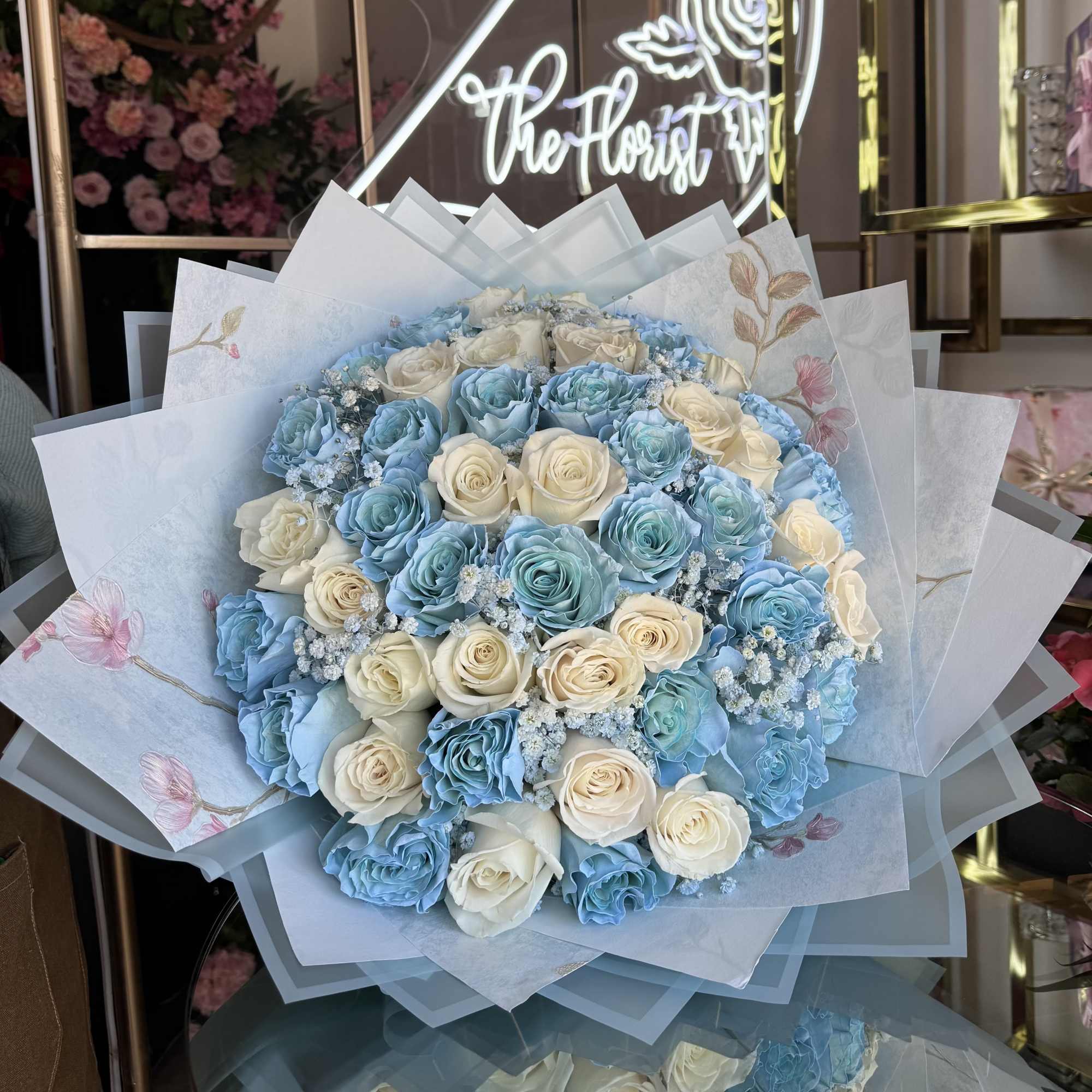 Bouquet of blue and cream roses wrapped in pale decorative paper