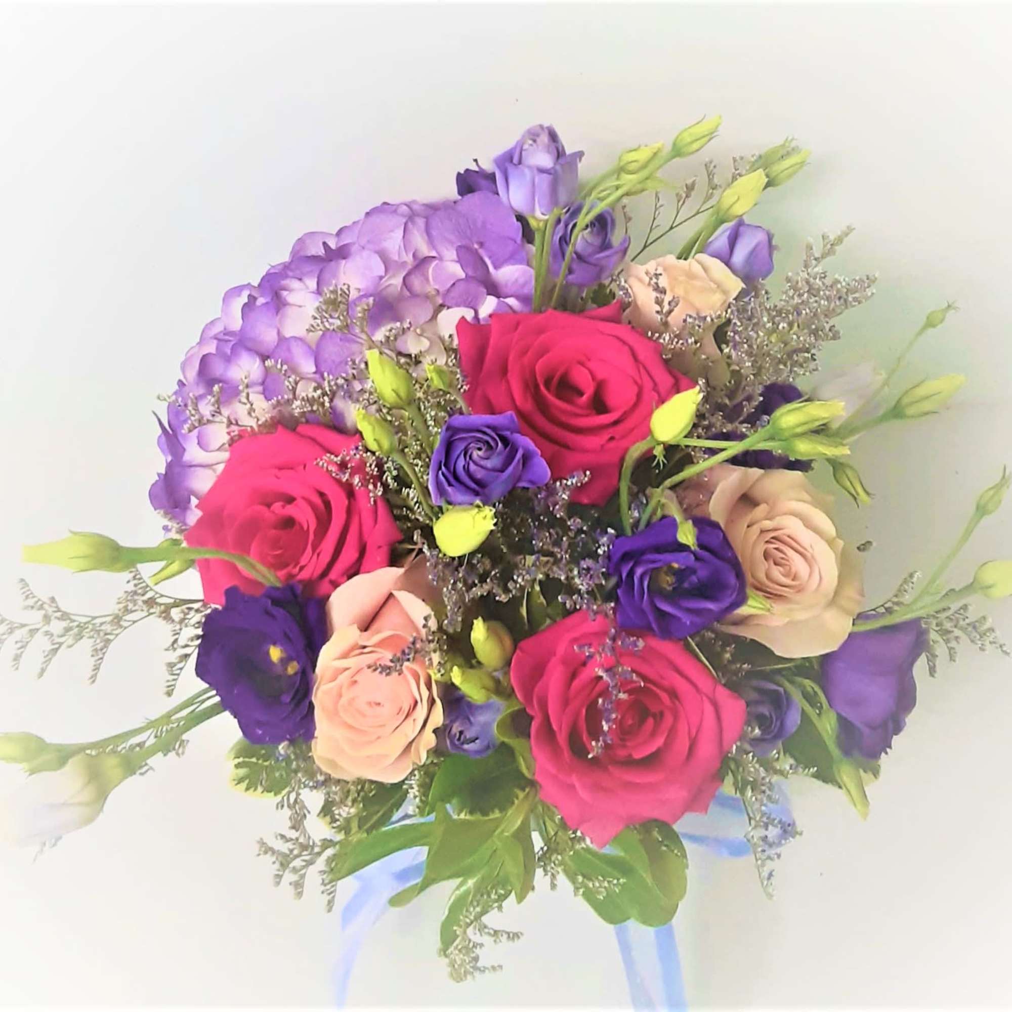 Bouquet of pink, purple, and peach roses with lavender blooms