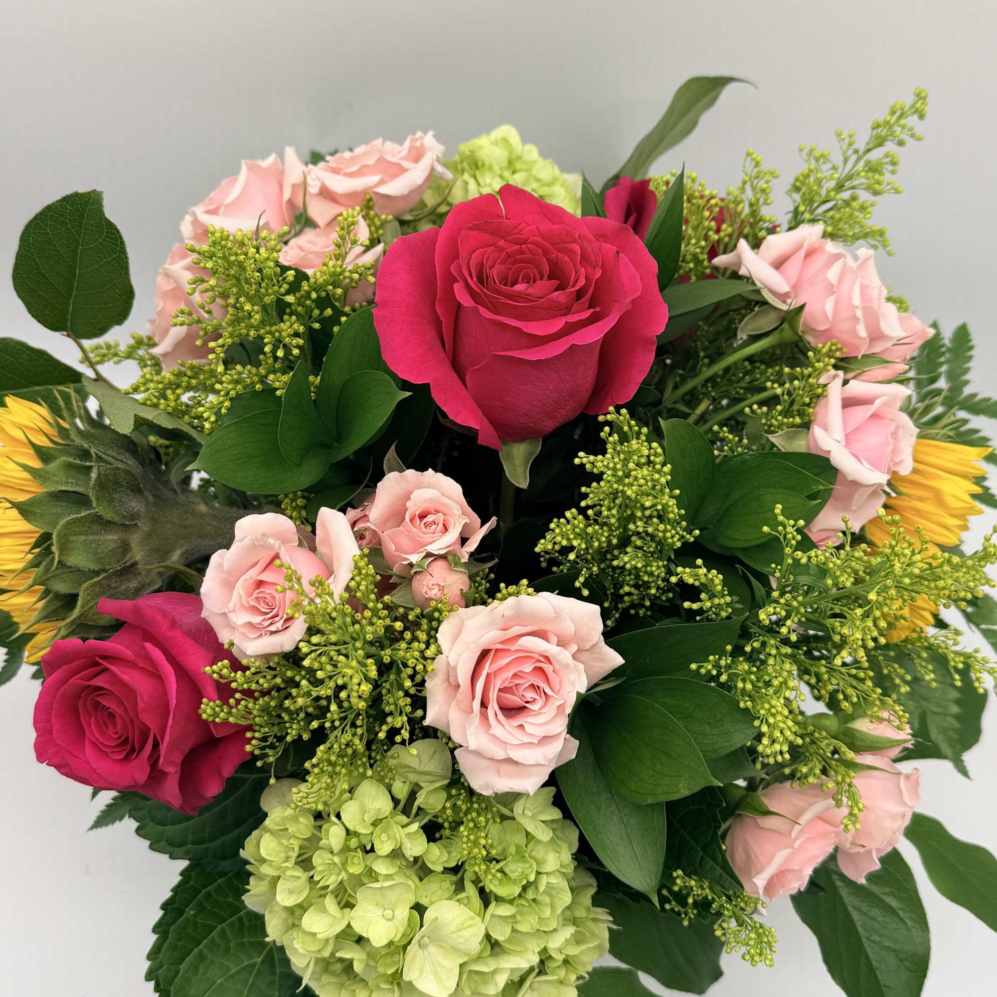 Bursting with color and freshness, this arrangement brings together vibrant roses, cheerful
