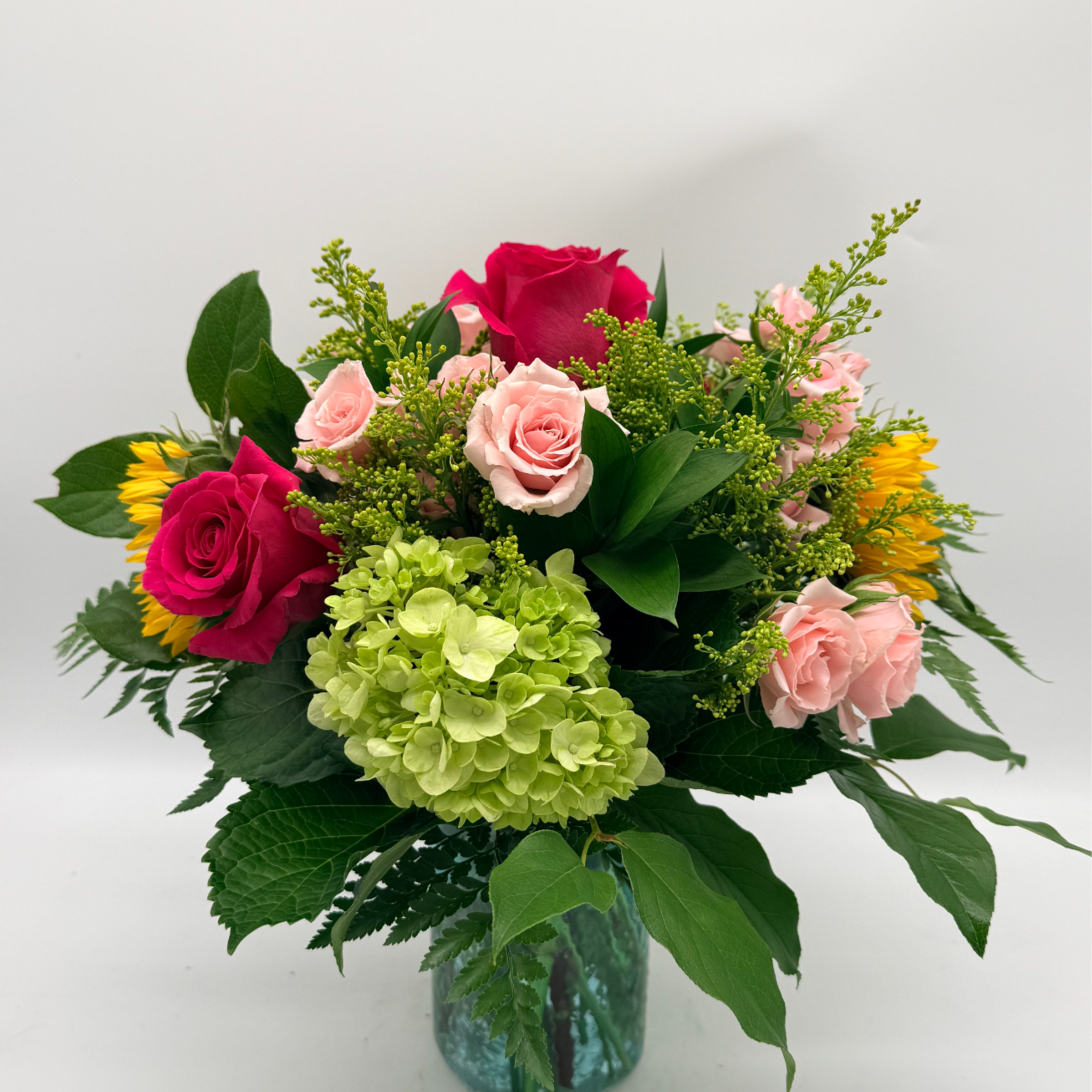 Bursting with color and freshness, this arrangement brings together vibrant roses, cheerful