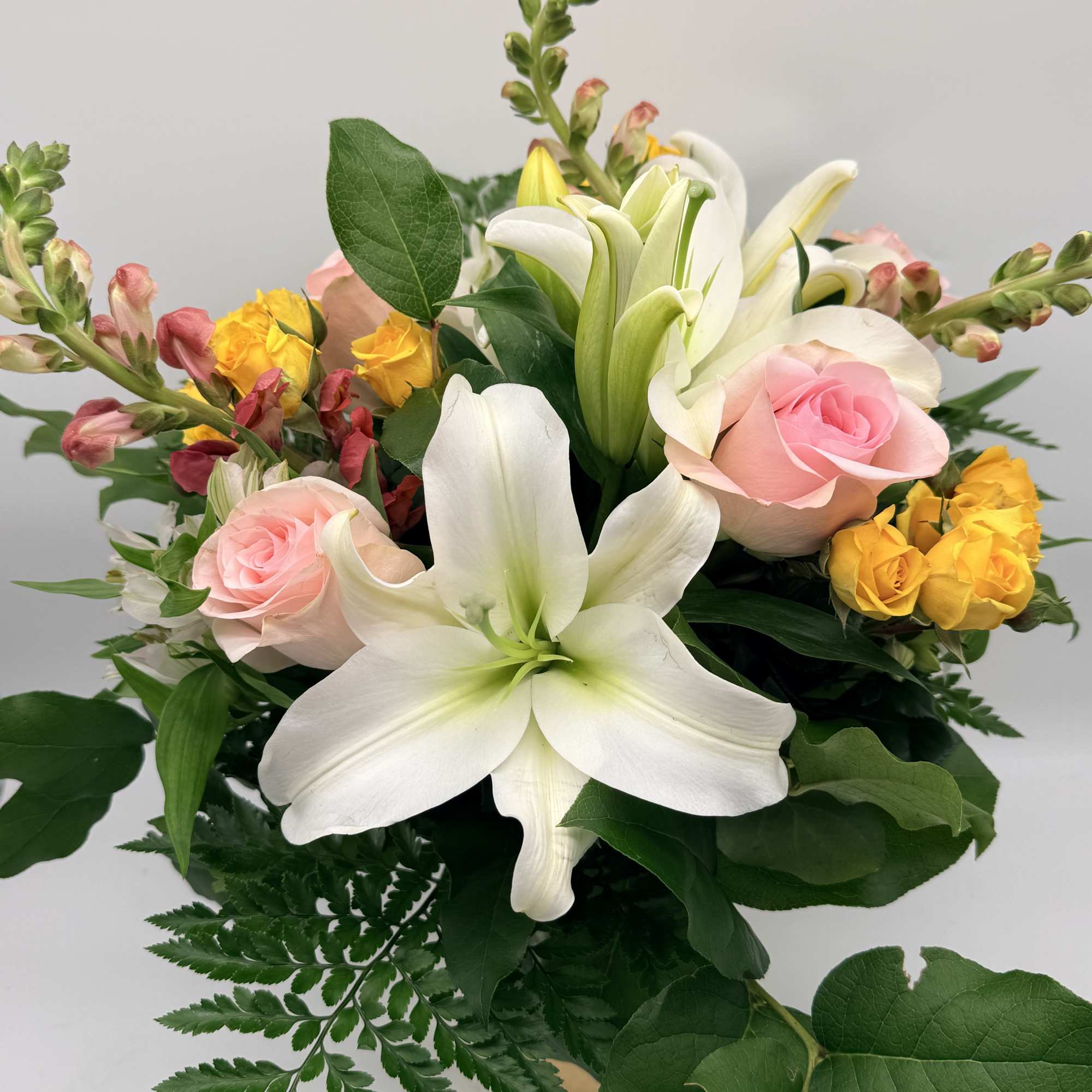 Inspired by the soft glow of golden hour, this arrangement blends lilies