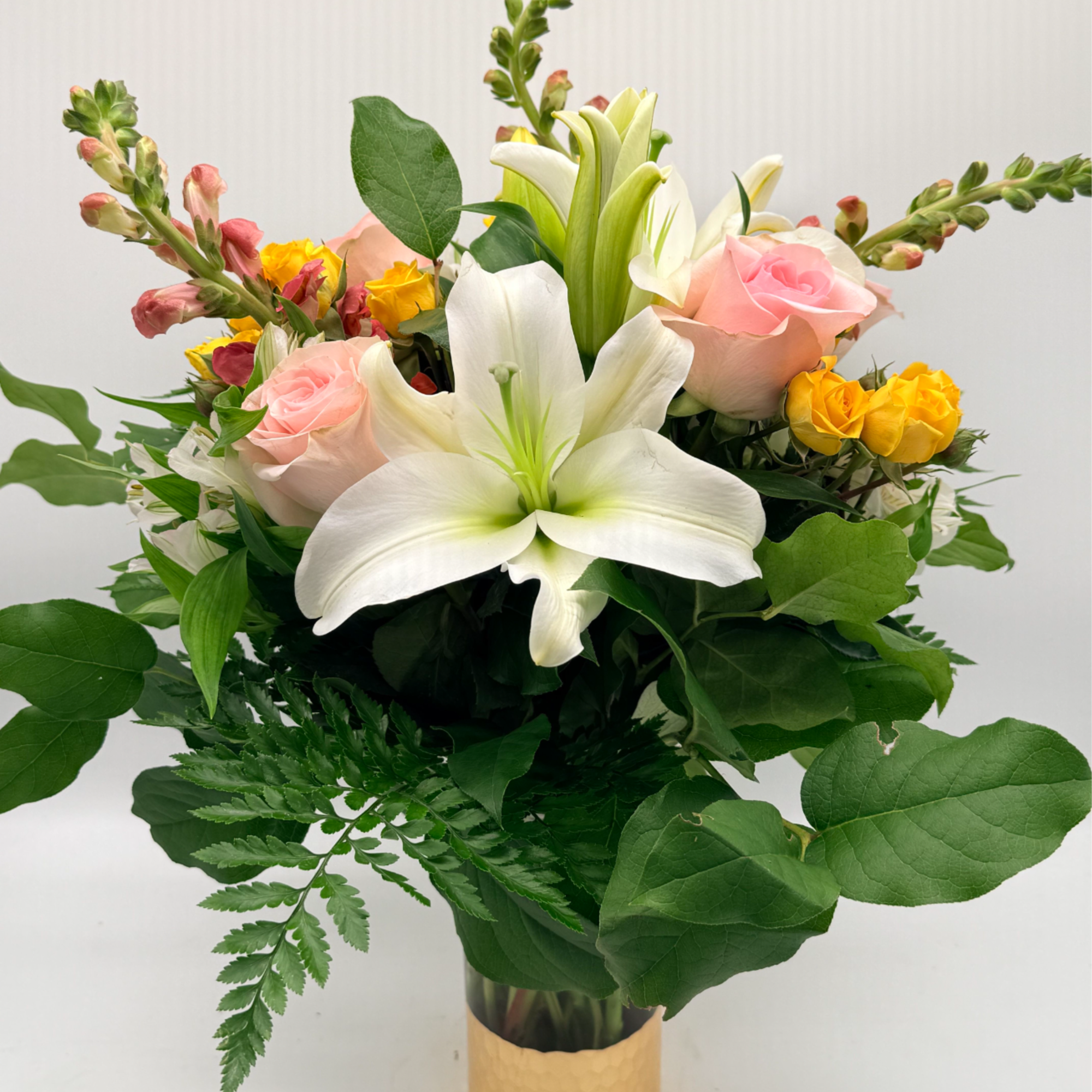 Inspired by the soft glow of golden hour, this arrangement blends lilies