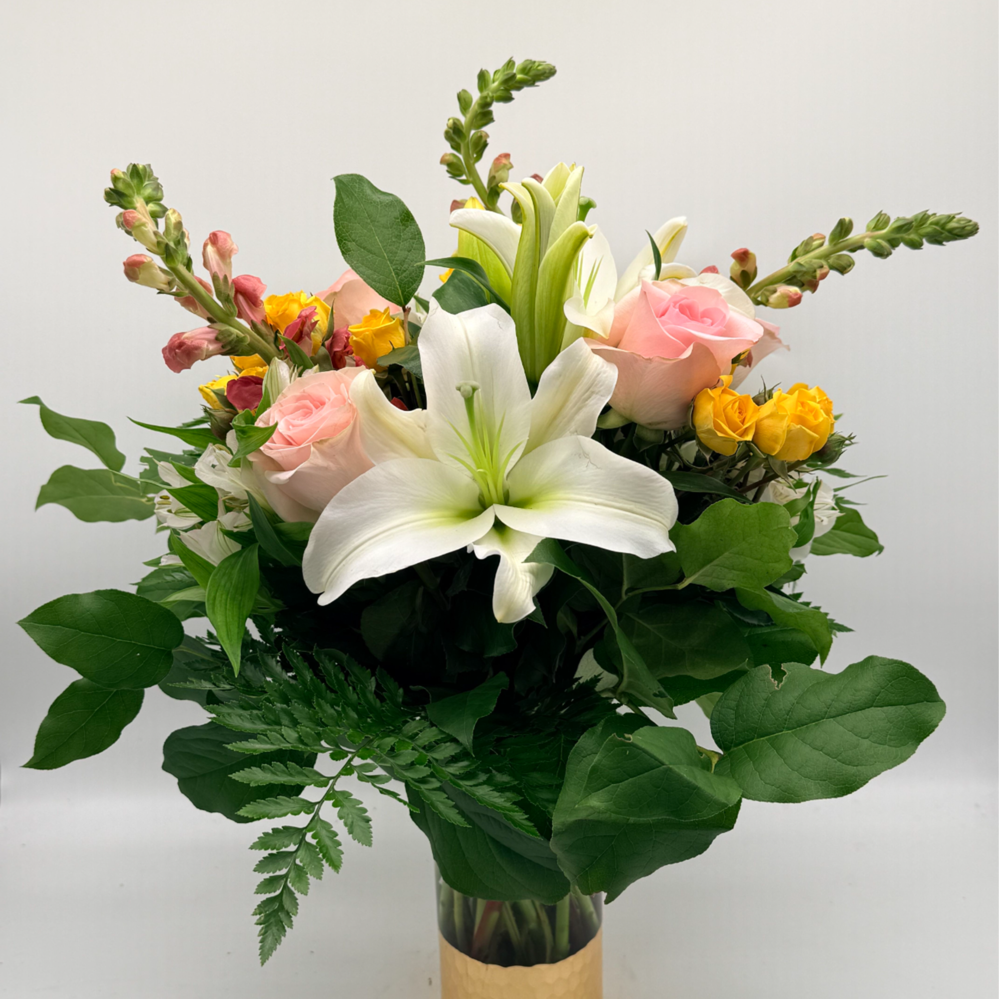 Inspired by the soft glow of golden hour, this arrangement blends lilies