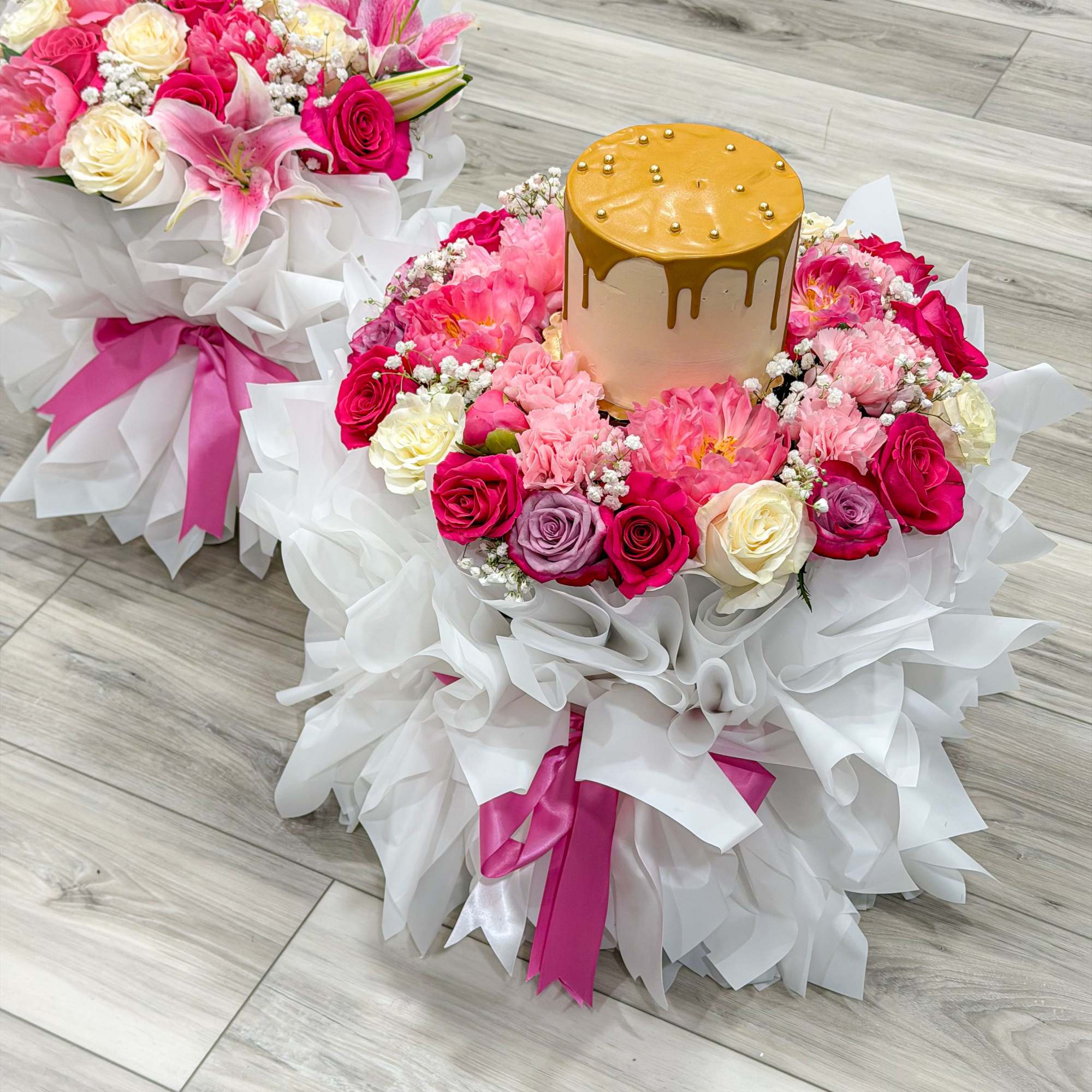 Two matching round bouquets wrapped in crisp white paper and tied with