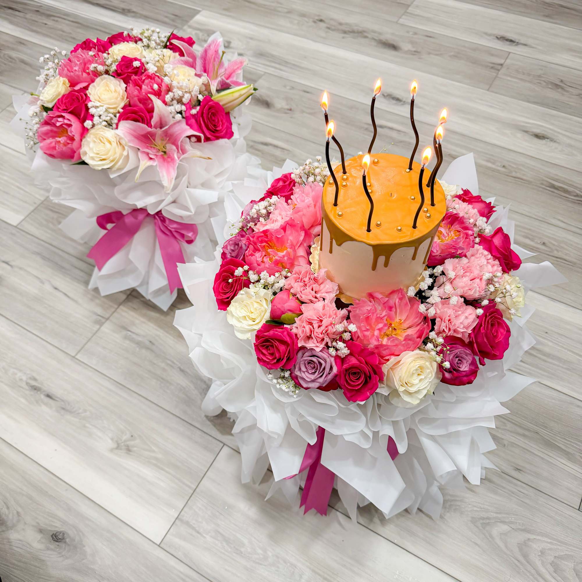 Two matching round bouquets wrapped in crisp white paper and tied with