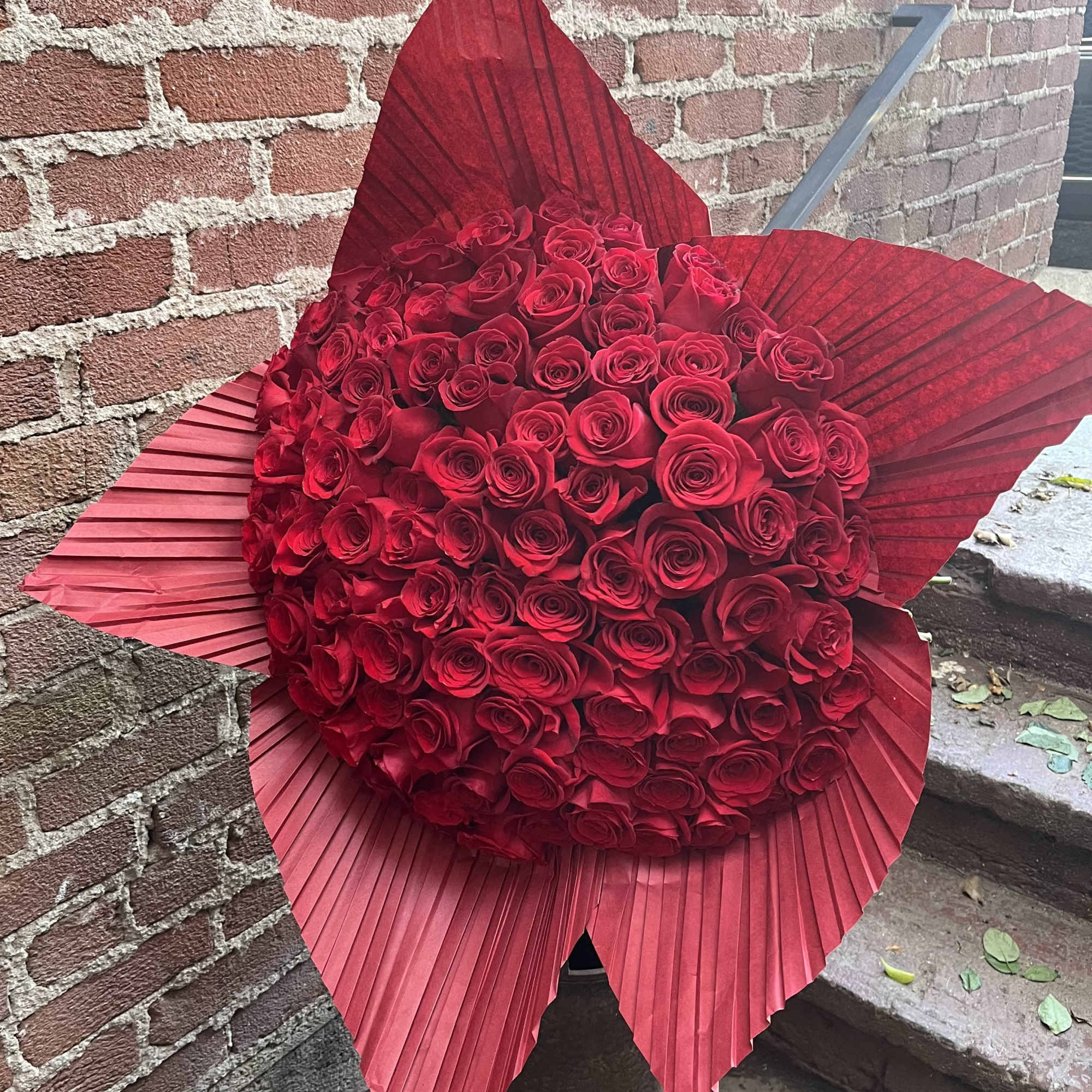 Large bouquet of red roses wrapped in red paper