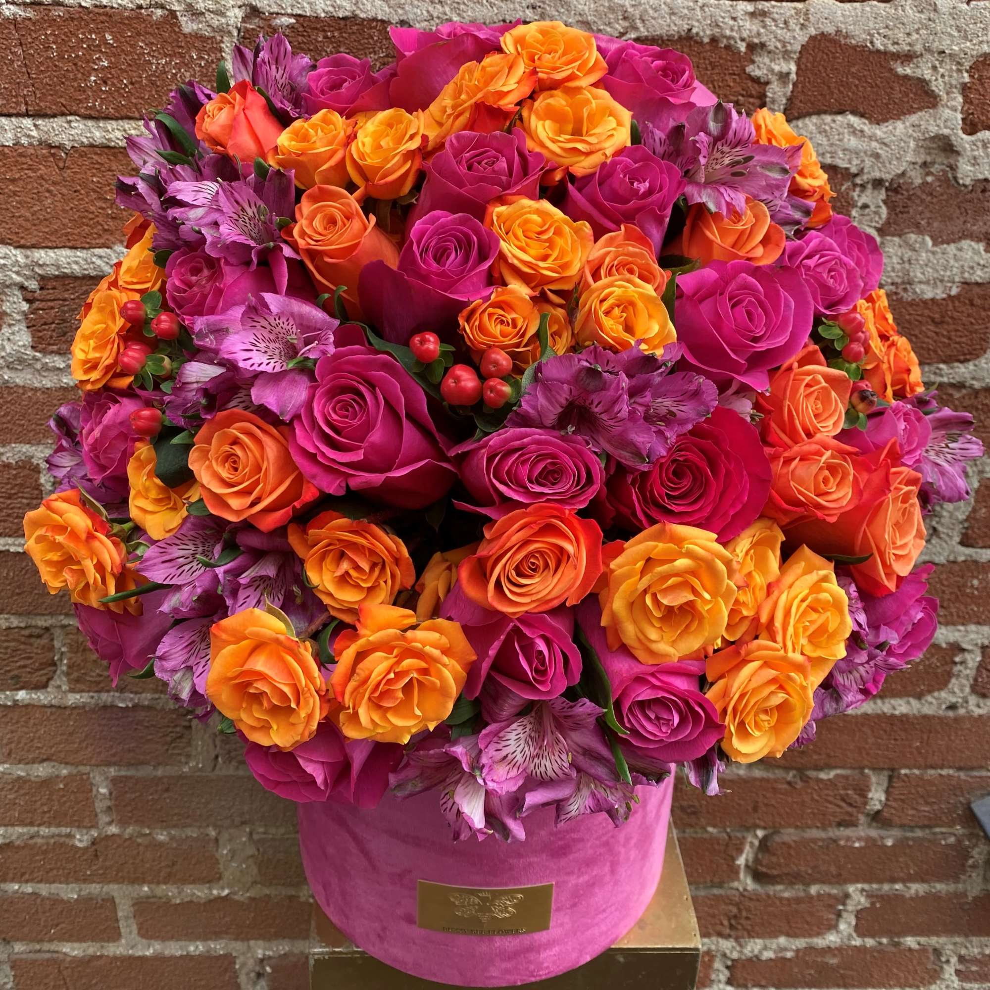 Bright pink and orange rose bouquet in a pink hat box