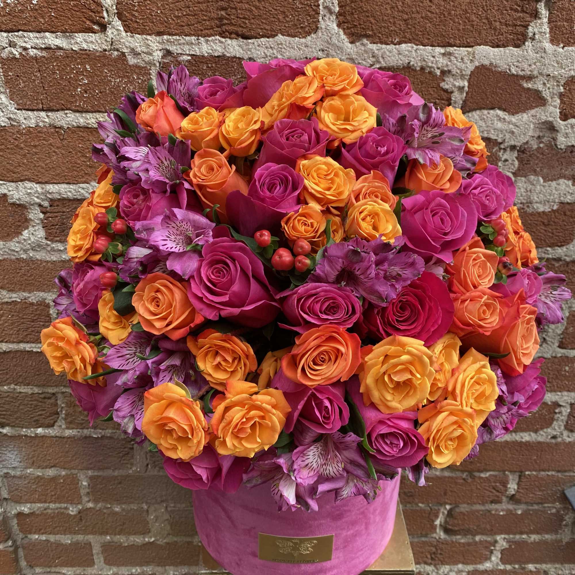 Bright pink and orange rose bouquet in a pink hat box