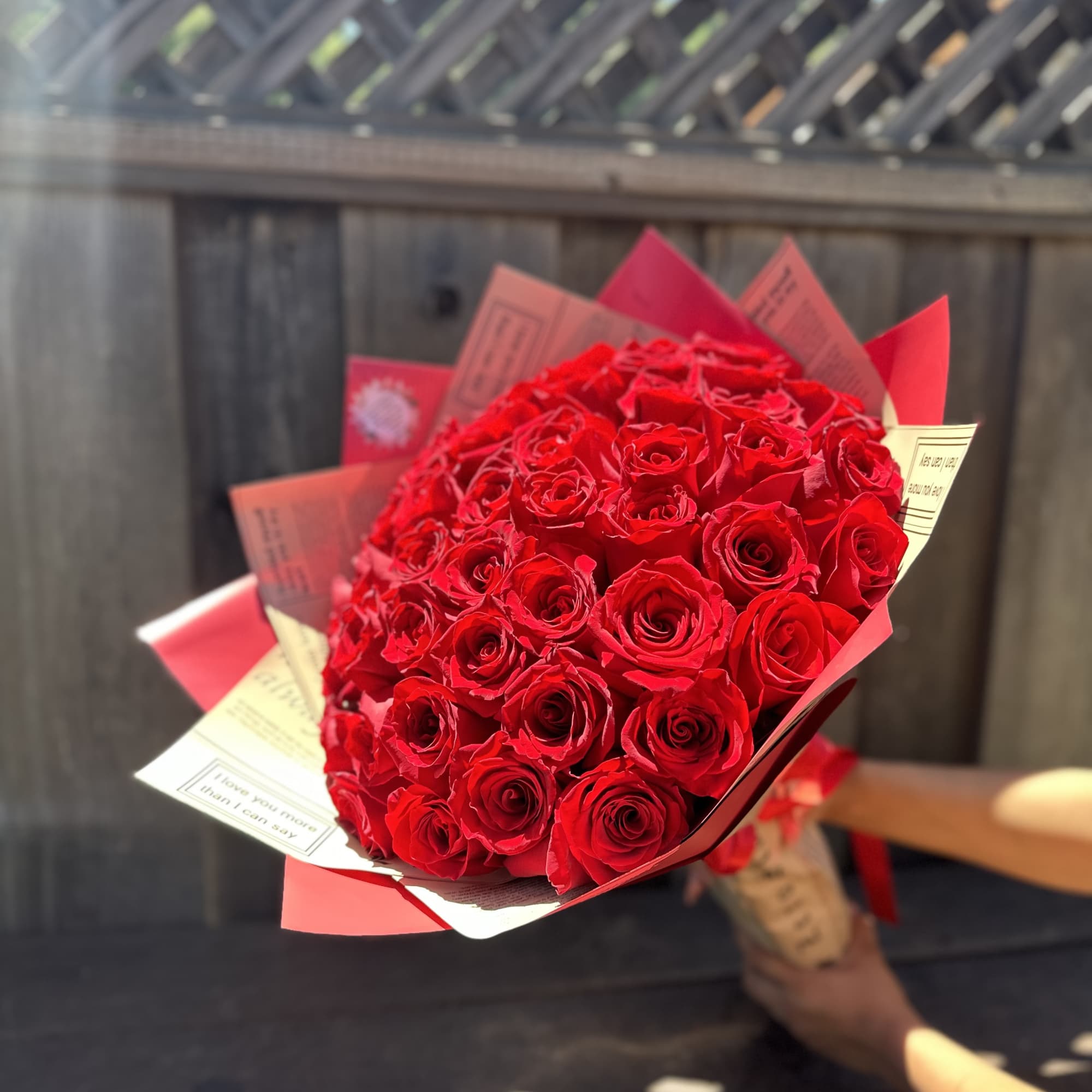 Bouquet of red roses wrapped in red and cream paper