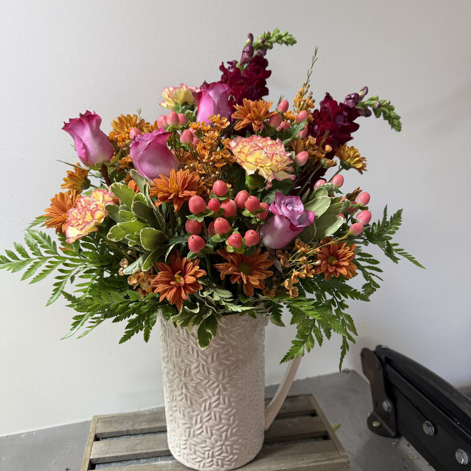 A decorative pitcher with fresh bloom with color and style of your
