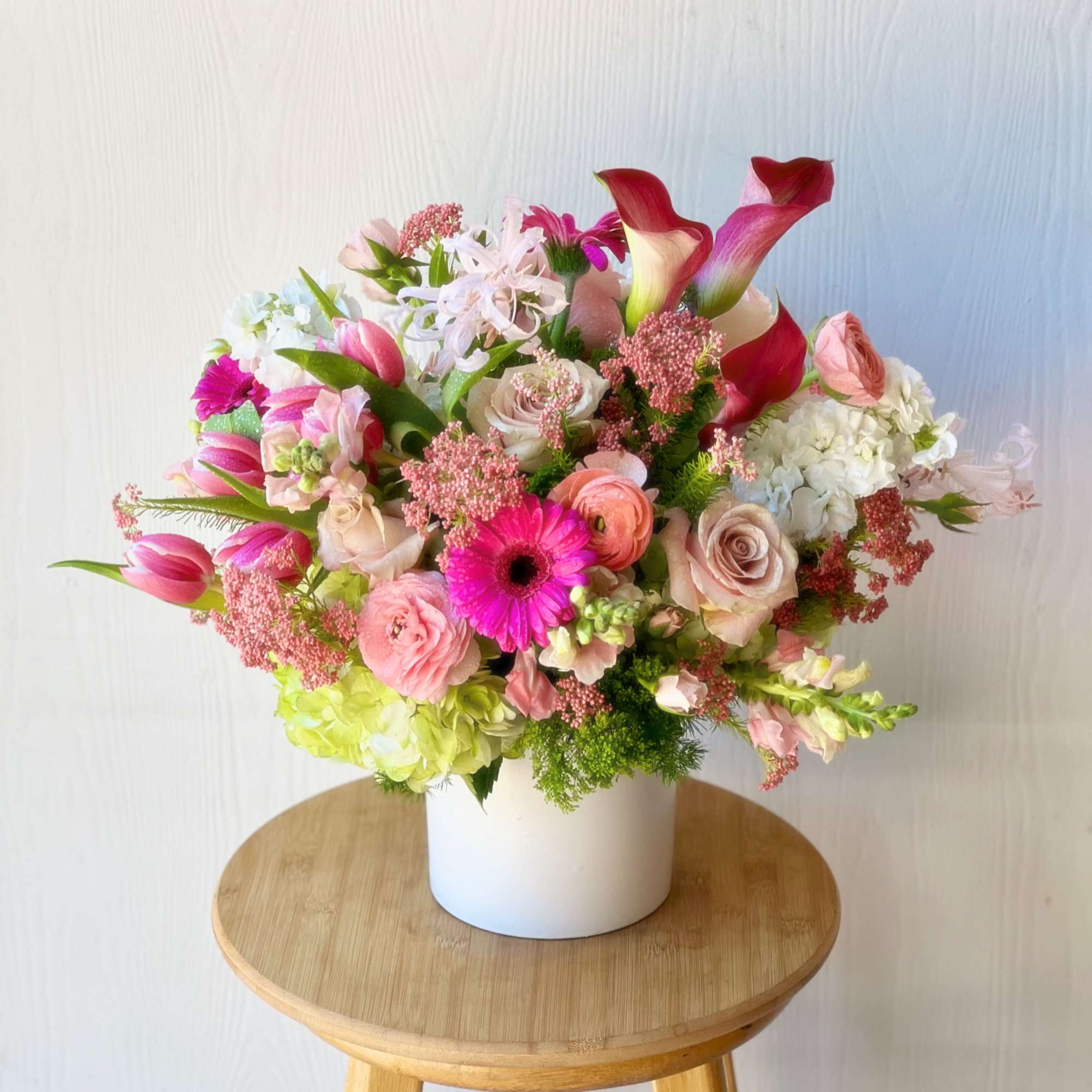 Mixed pink and white flower arrangement in a white vase