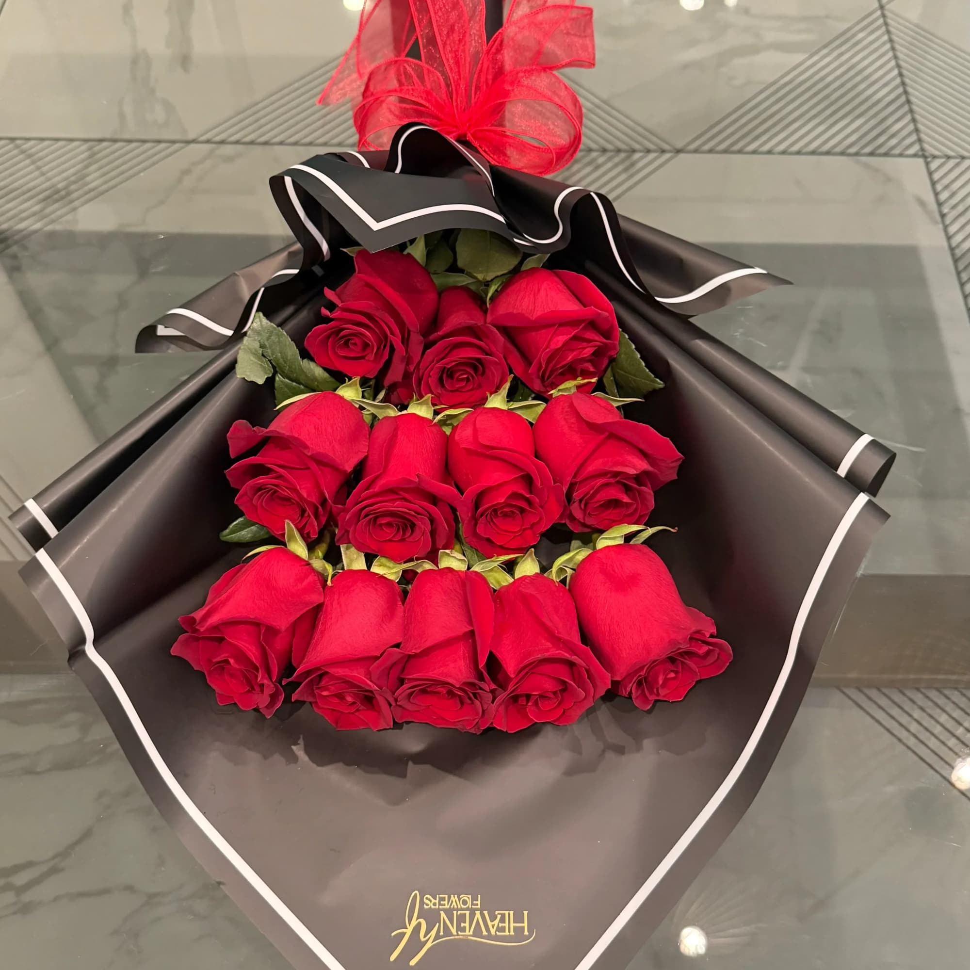 Bouquet of red roses wrapped in black paper with a red ribbon
