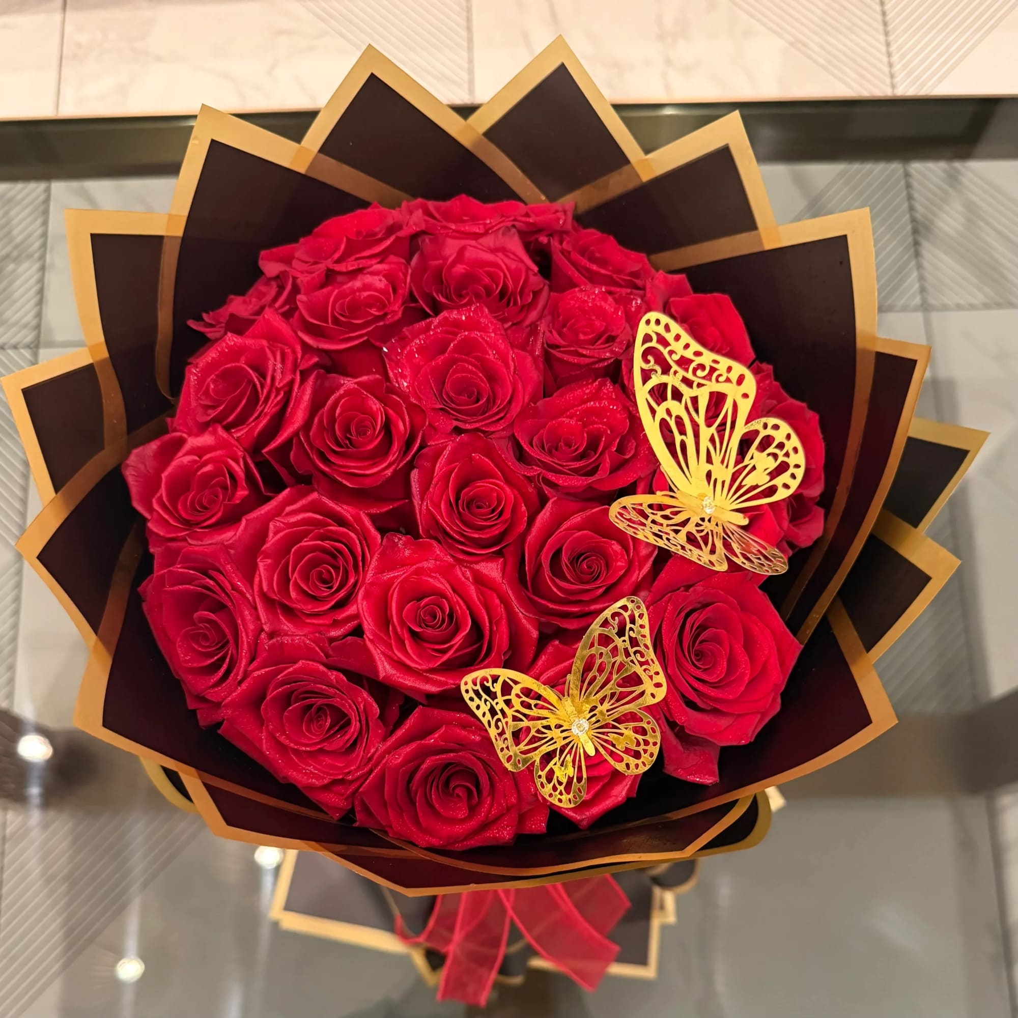 Bouquet of red roses with two gold butterfly decorations