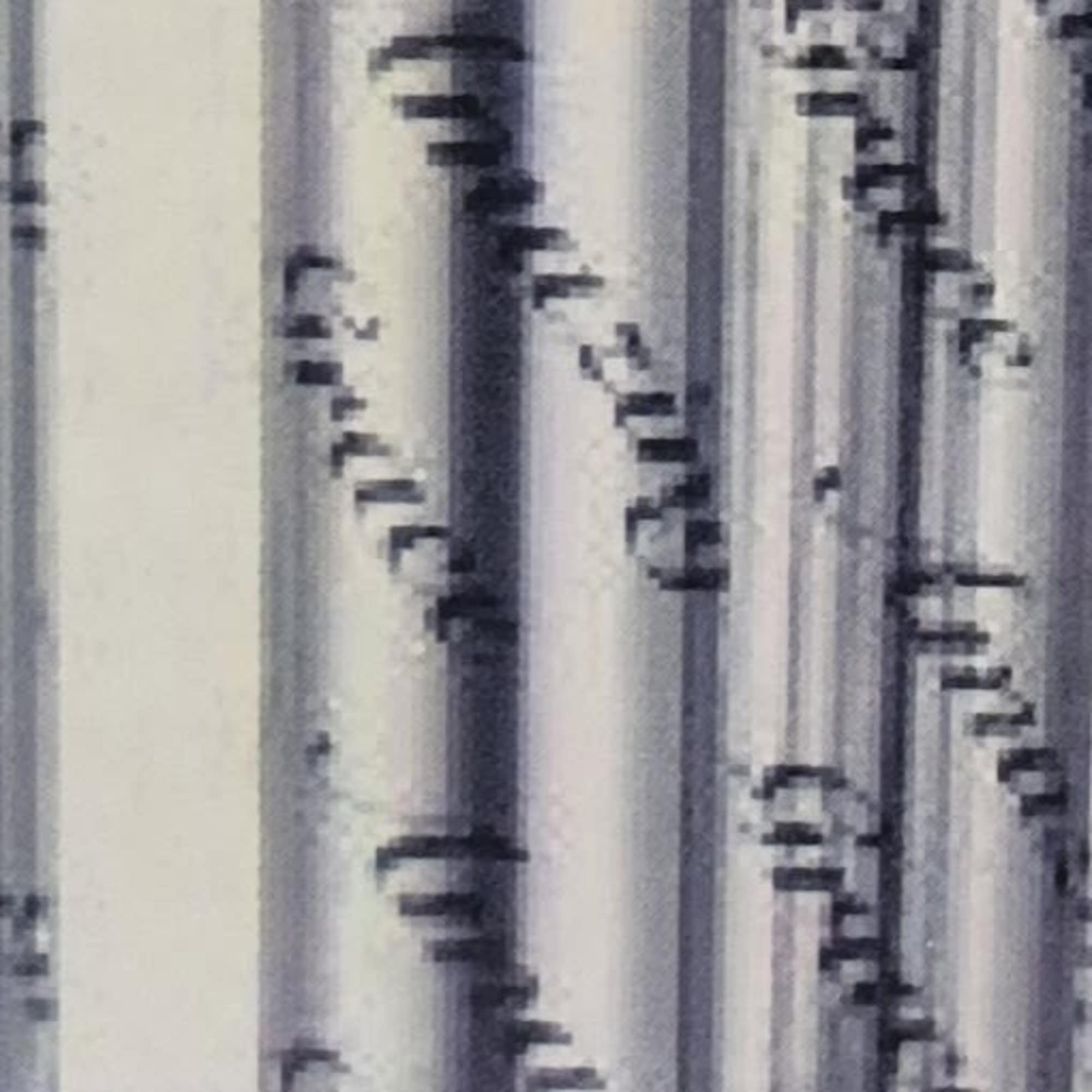 Close-up of silver cylindrical candles with cursive writing.