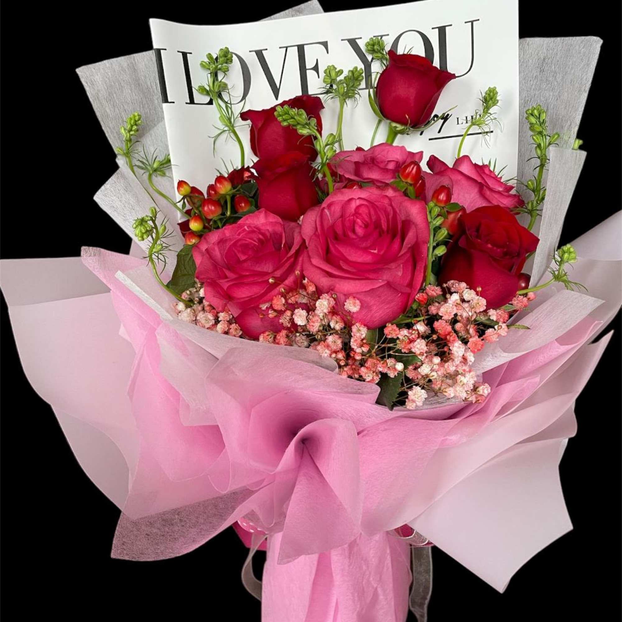 Pink and red rose bouquet wrapped in pink paper with a "LOVE YOU" card