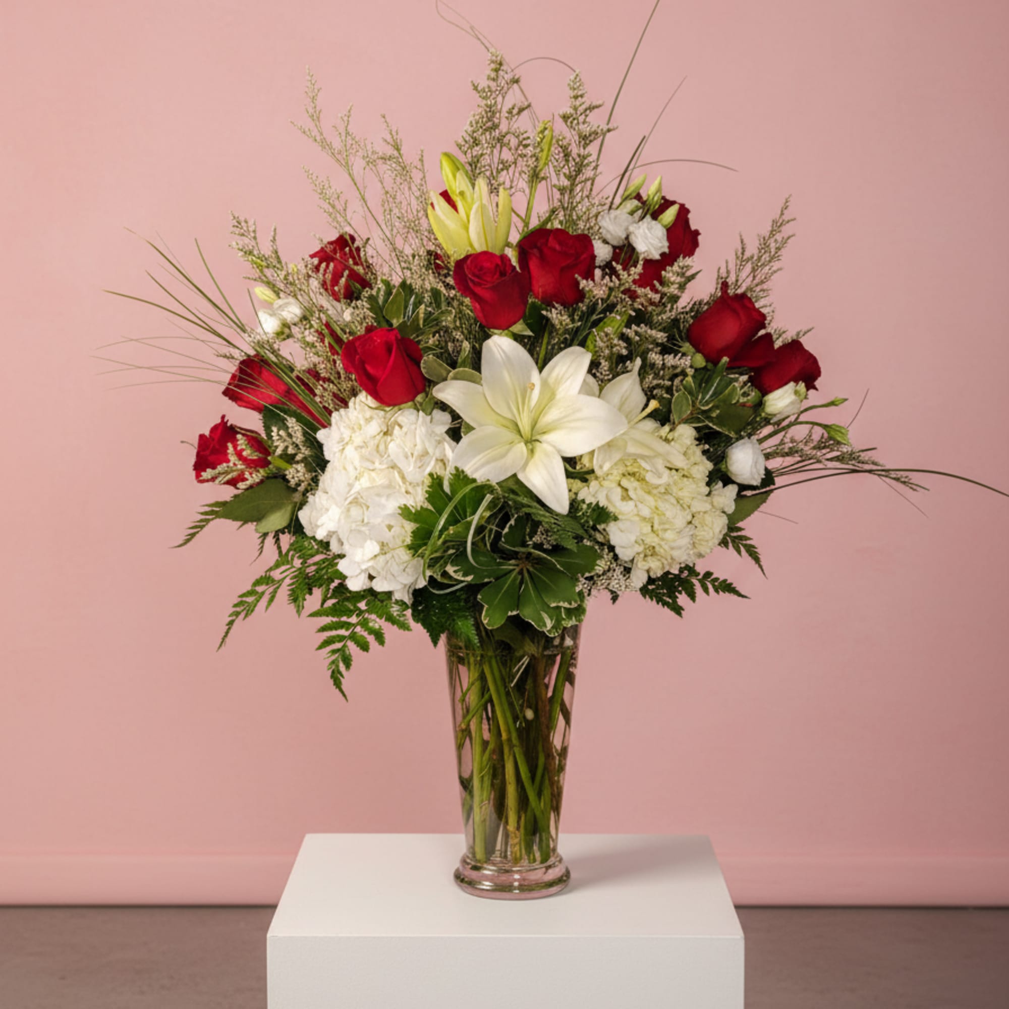 Red roses and white lilies in a clear glass vase