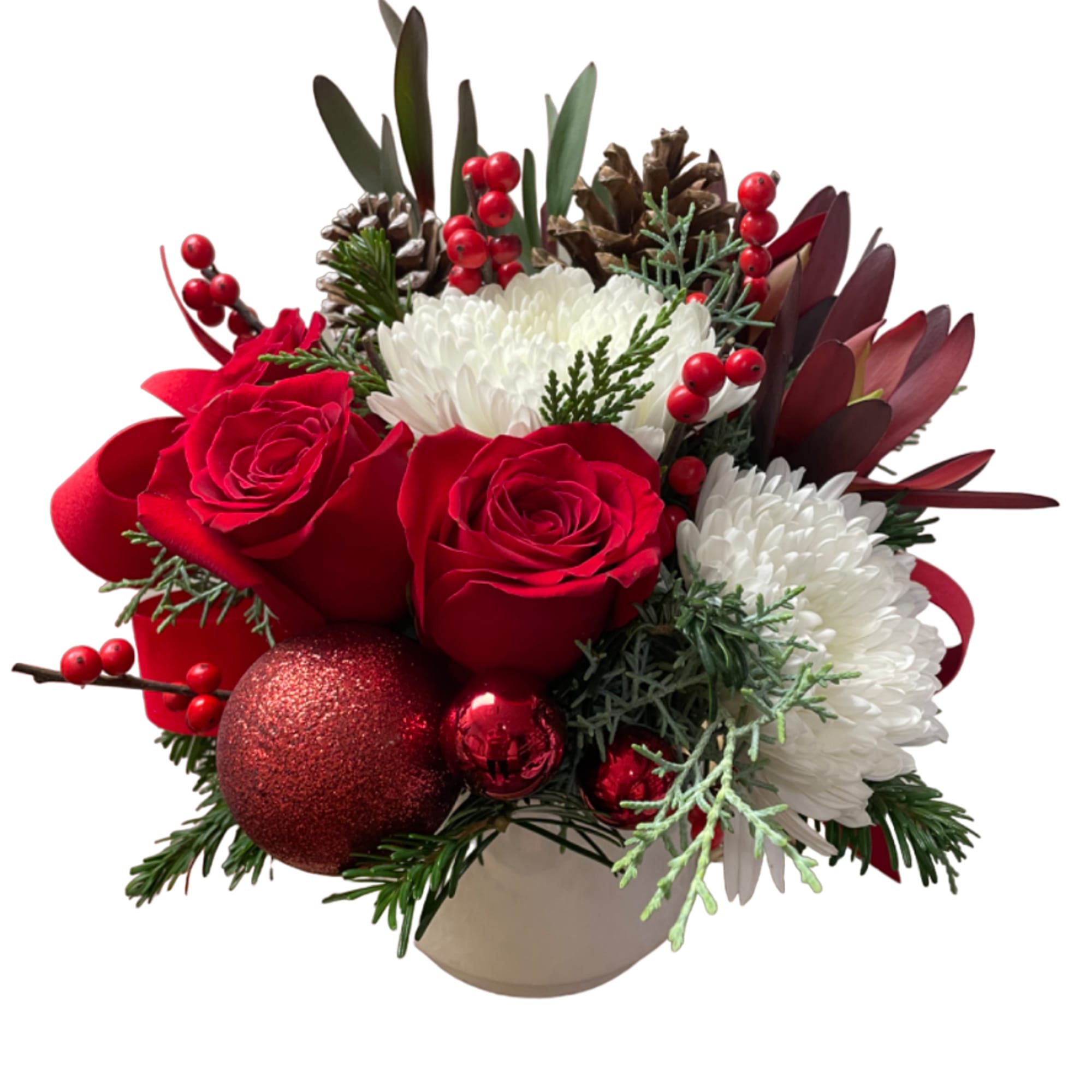 Red roses and white mums in a beige vase with pinecones and ornaments