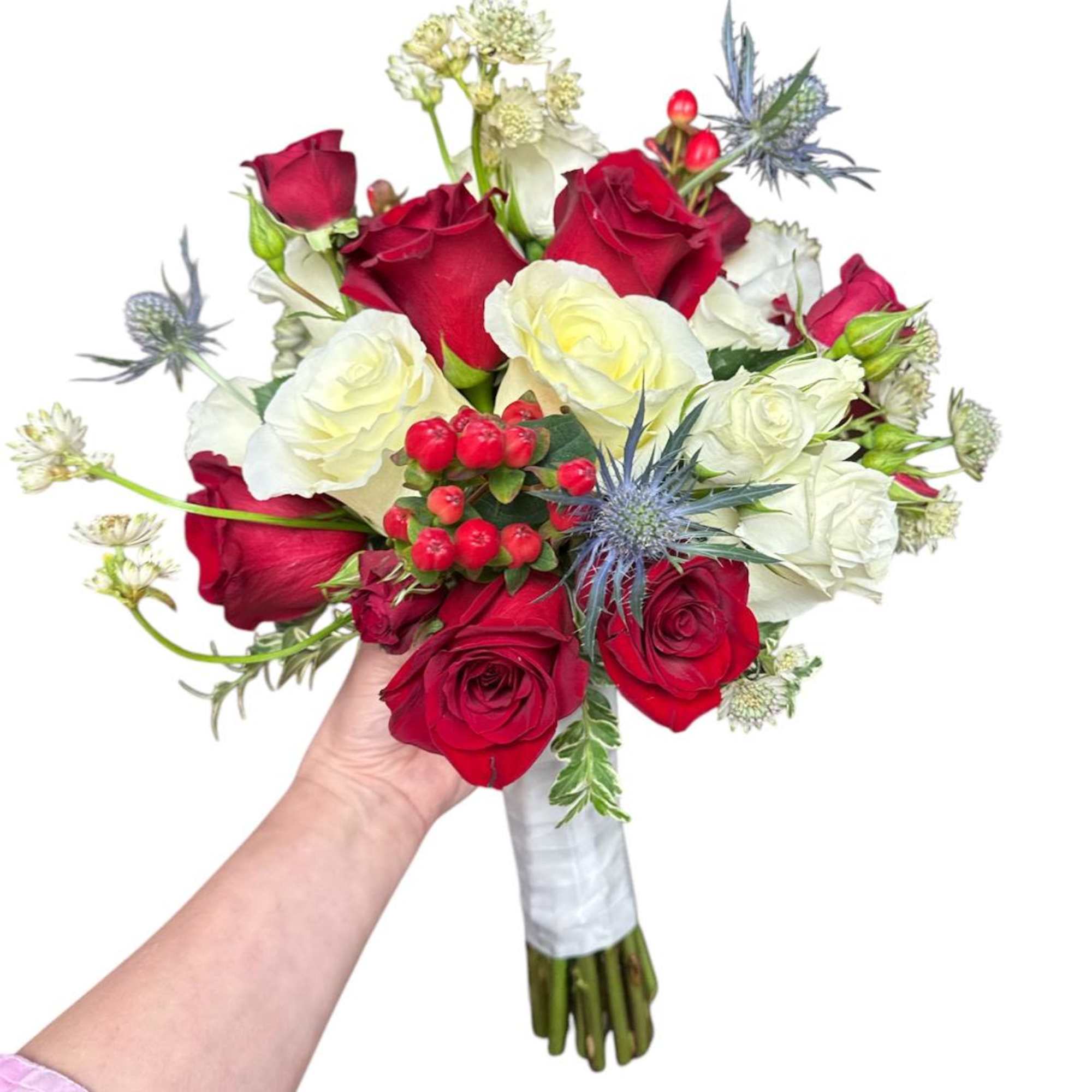 Handheld bouquet of red and white roses with blue thistle accents