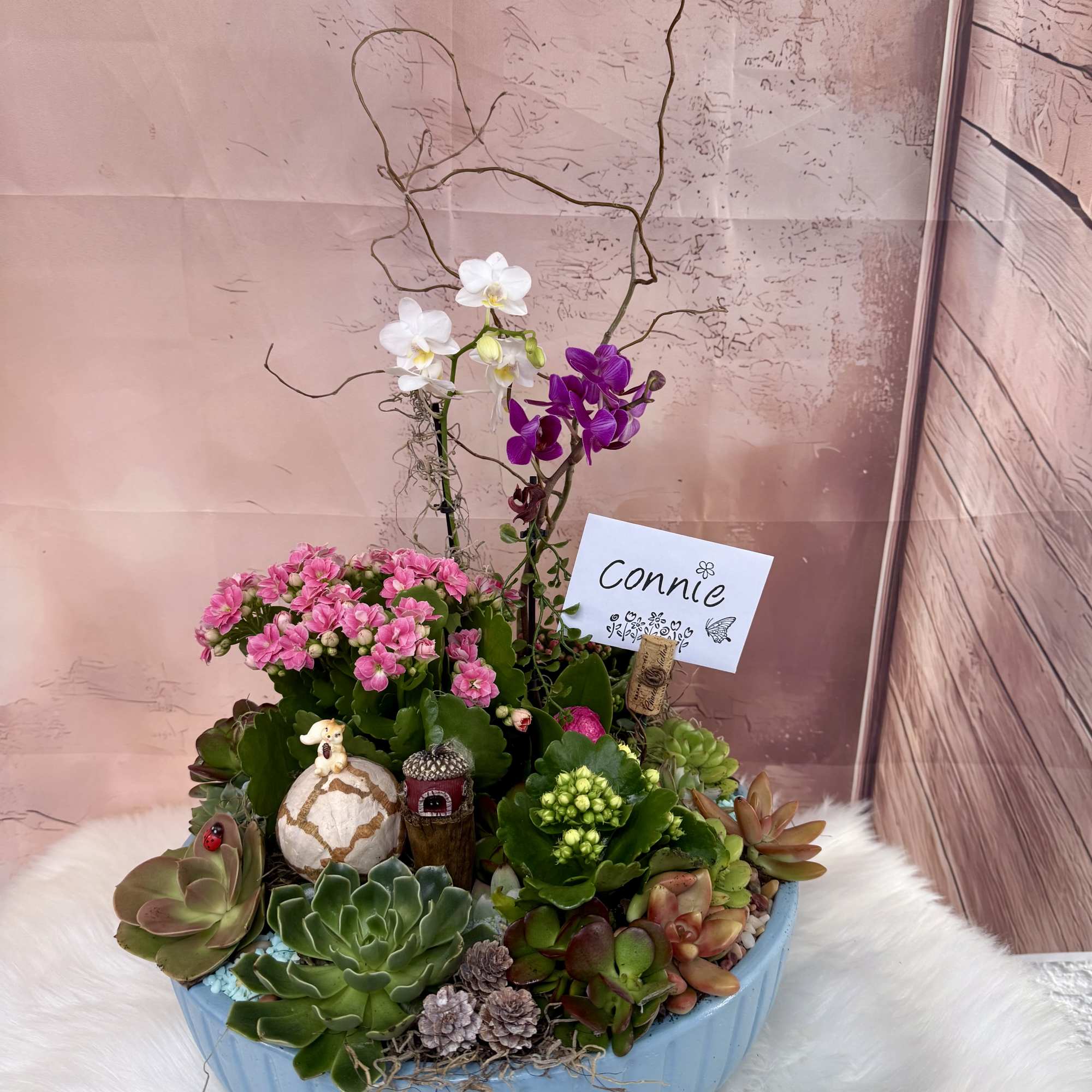 A modern, nature-inspired arrangement featuring a vibrant yellow and magenta orchid as