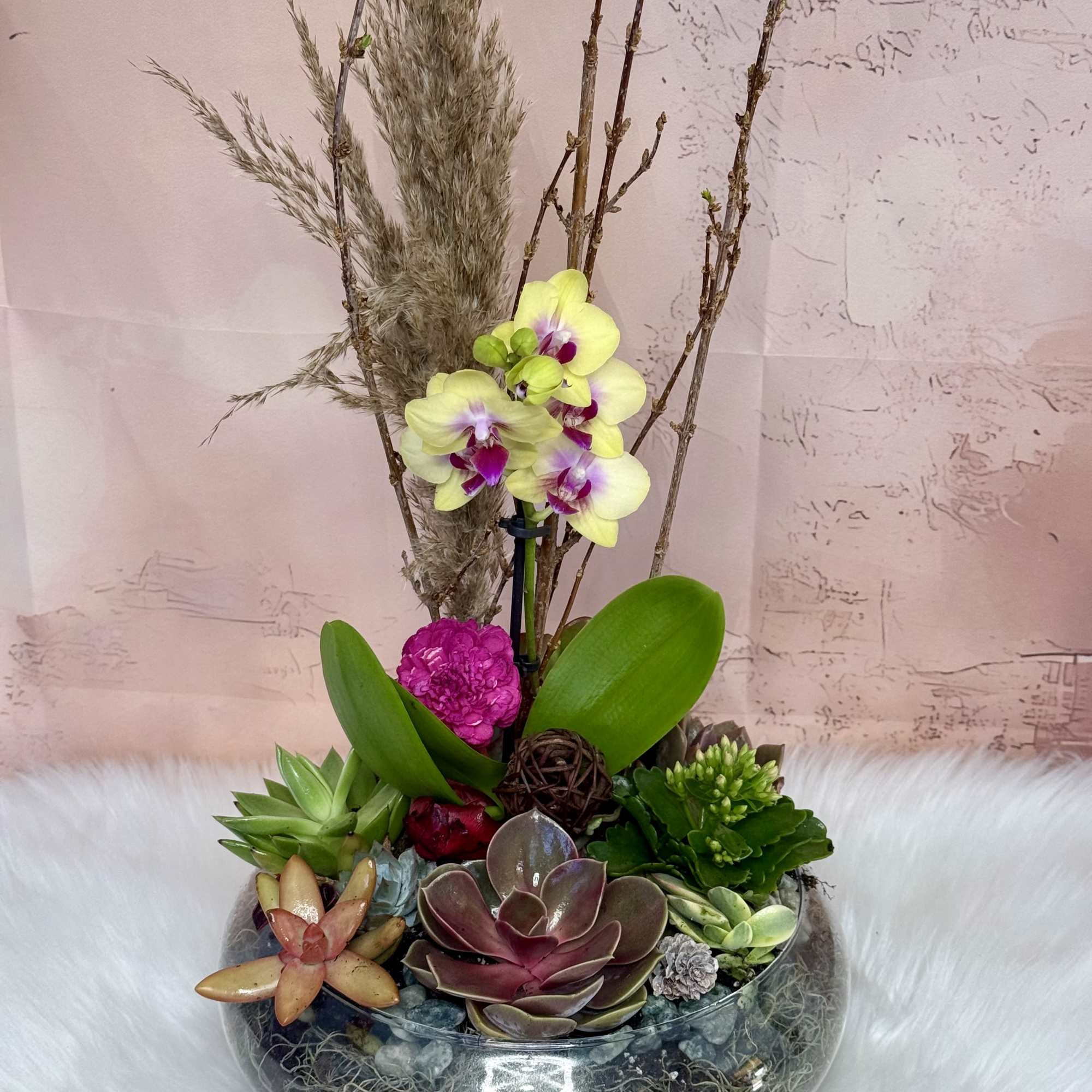 A modern, nature-inspired arrangement featuring a vibrant yellow and magenta orchid as