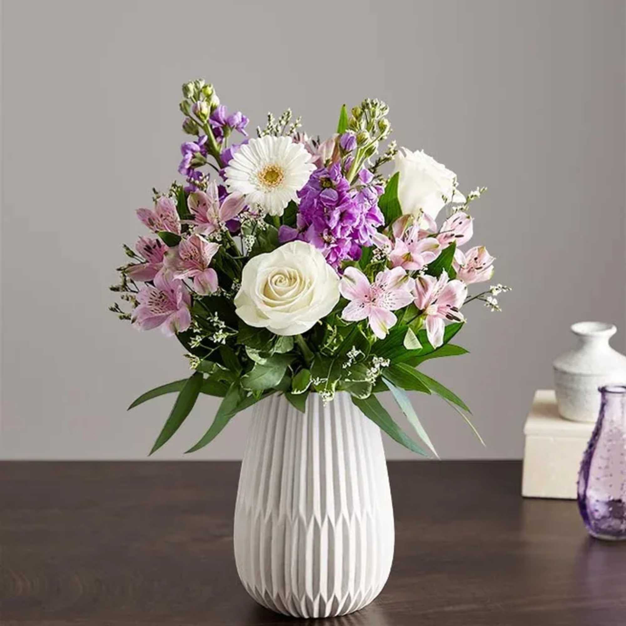 Soft lavender stock and crisp white roses mingle with lavender alstroemeria in