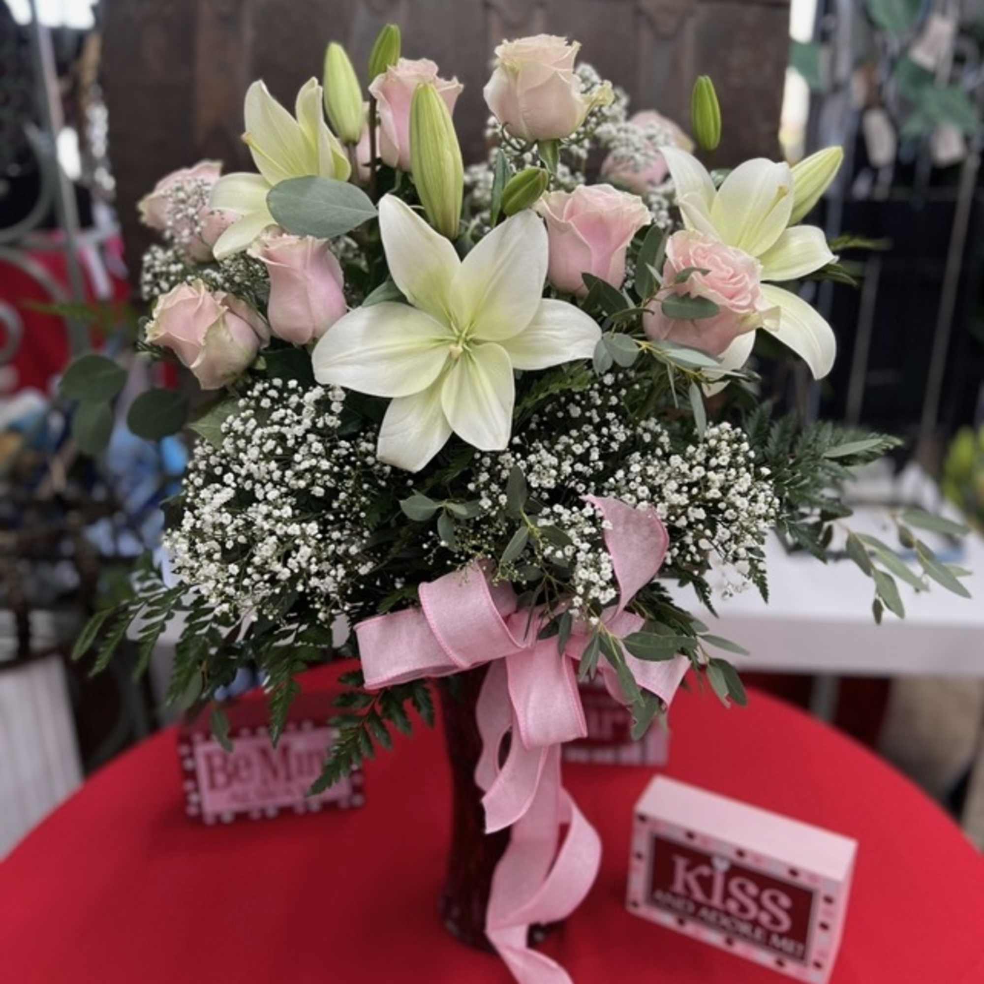 Bouquet of pink roses and white lilies with a pink ribbon