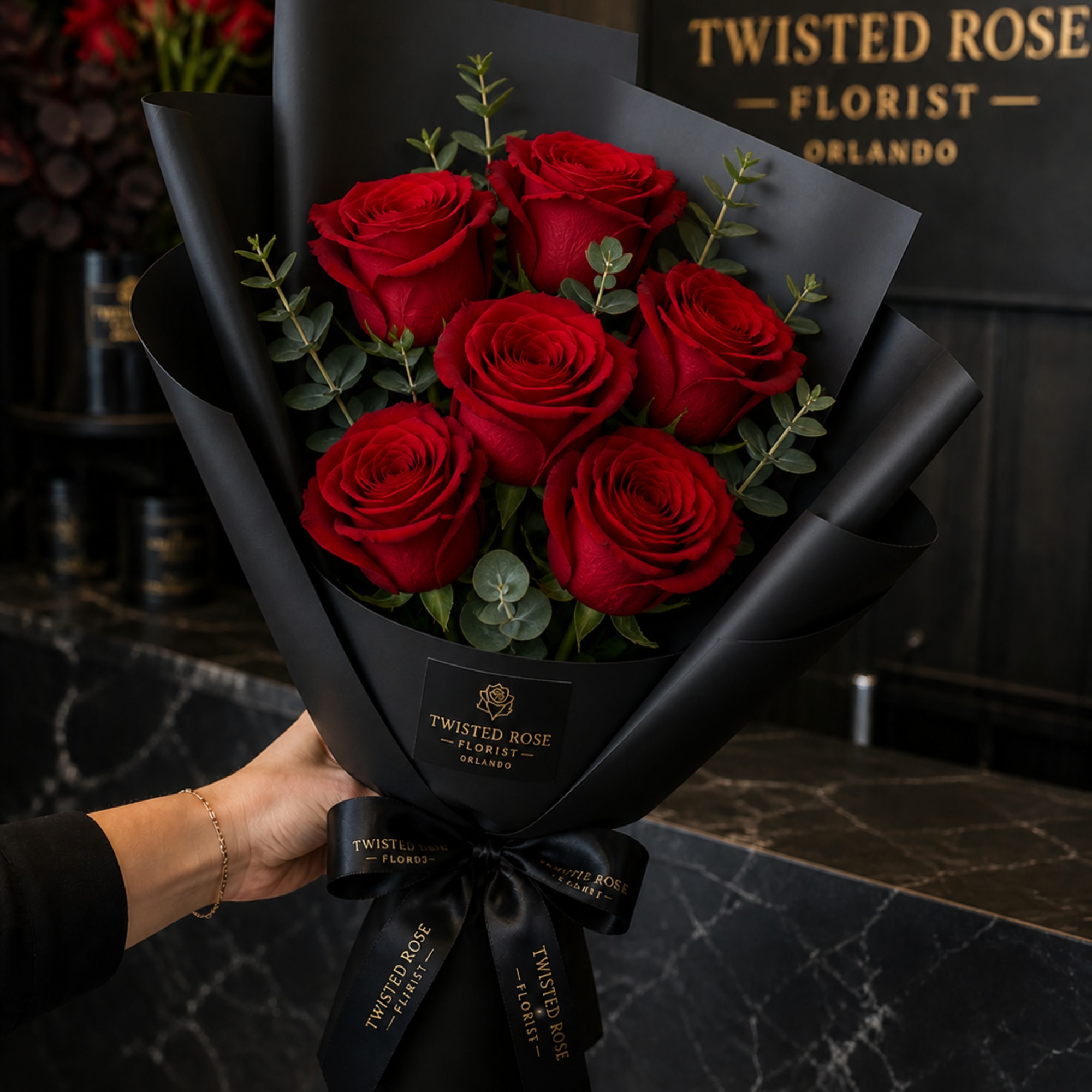 Three deep red roses set against matte black wrap create an instantly