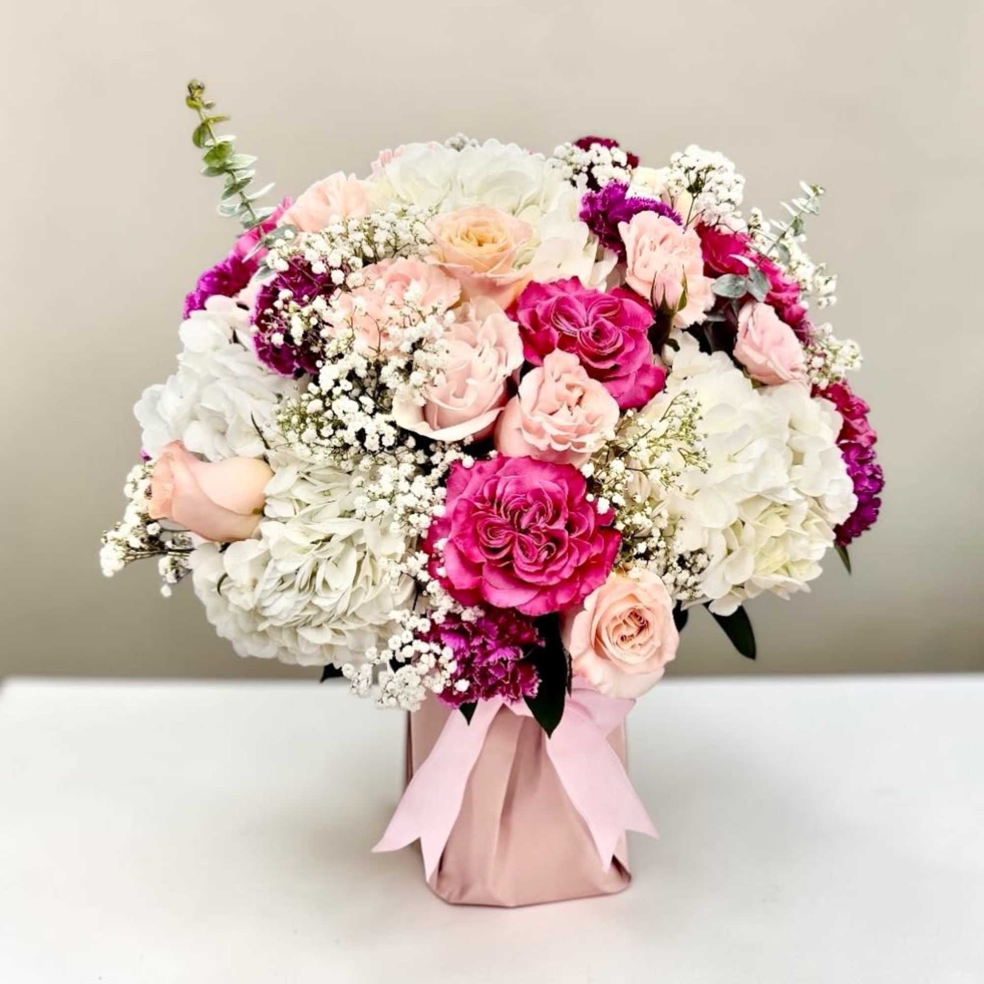 Lush pink and white roses mingle with voluminous white hydrangeas and delicate