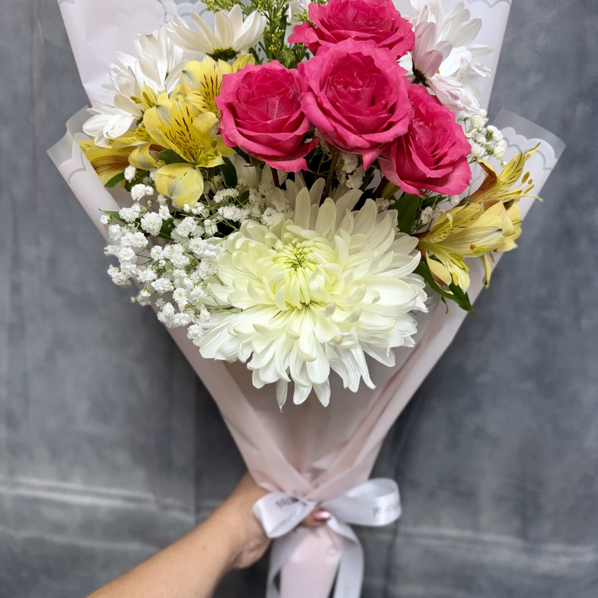 Our petite Pink Breeze hand-tied bouquet features cheerful mums, spray roses, daisies