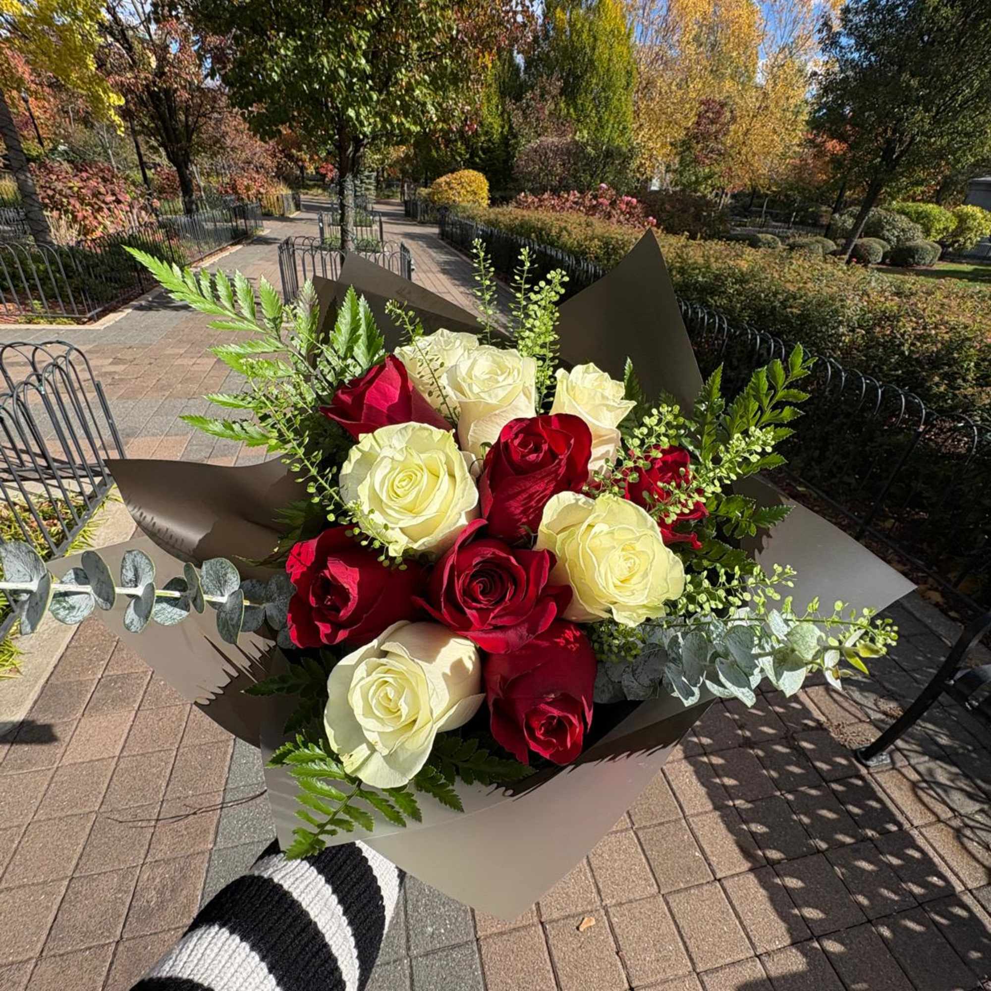 Bouquet of red and cream roses wrapped in brown paper