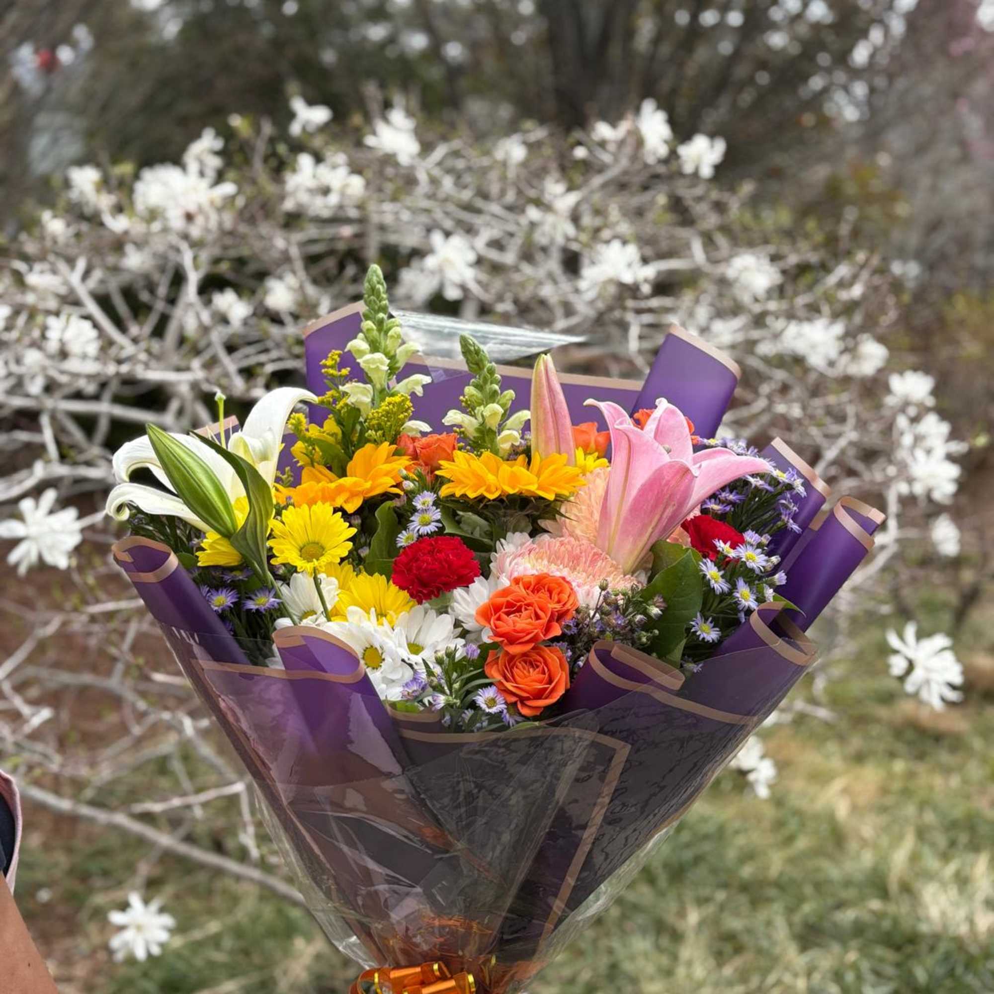 A cheerful bouquet with a mix of seasonal flowers. Designed, packaged, and