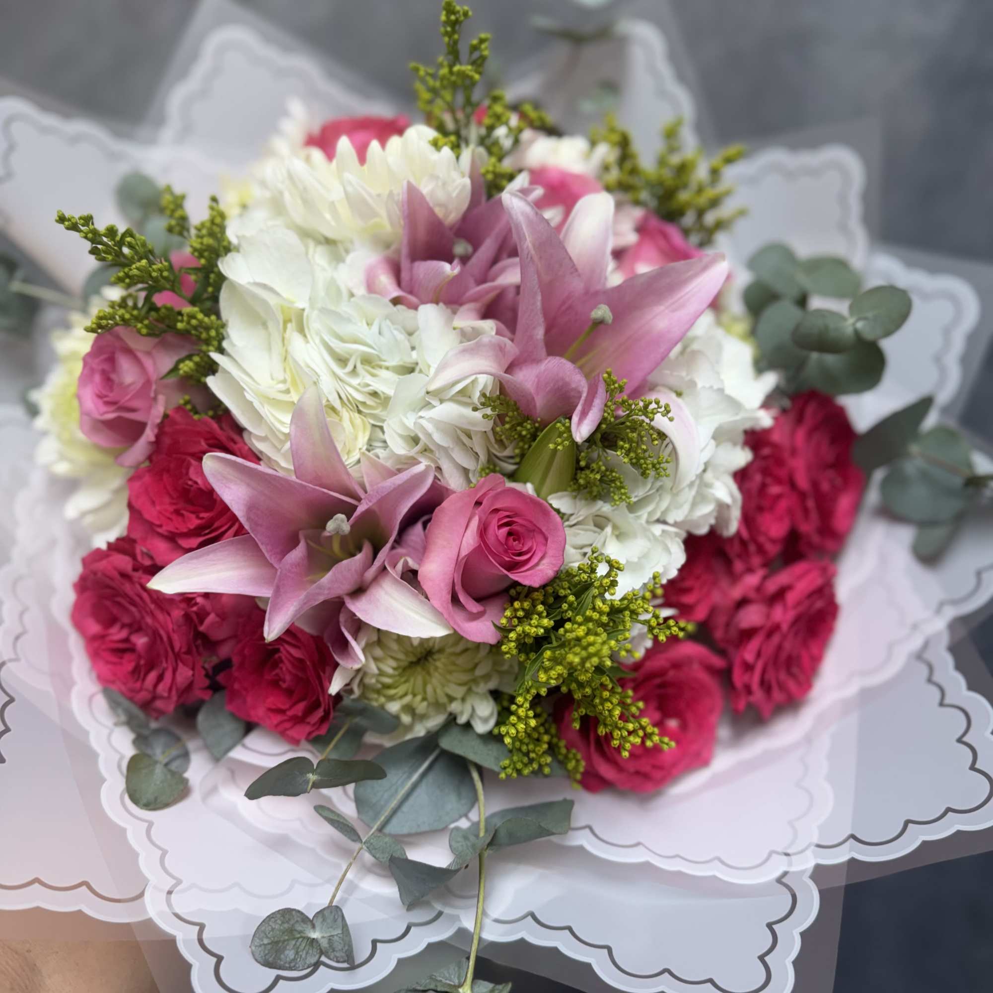 An enchanting mix of pure white mums and hydrangeas paired with shades