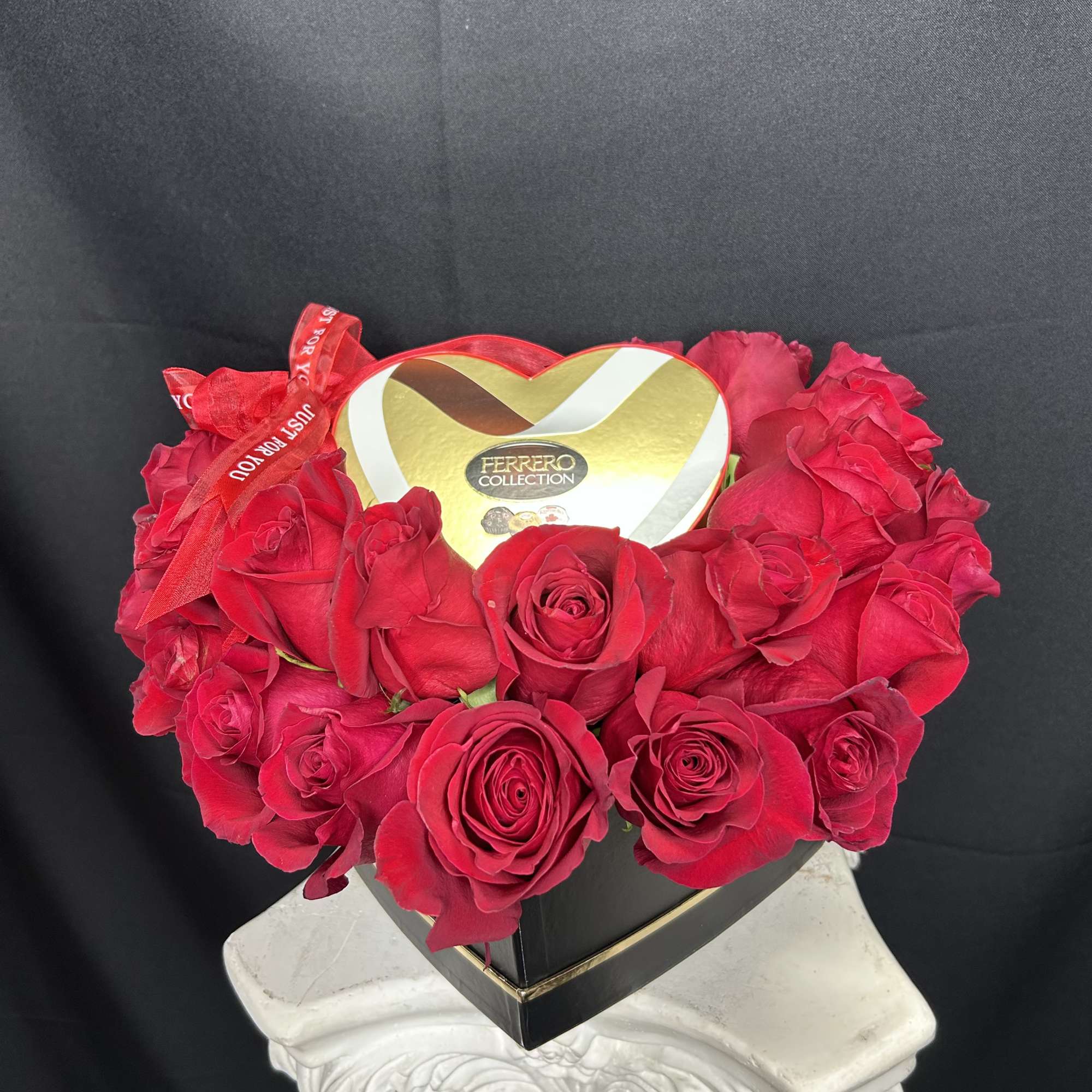 Heart-shaped box of red roses with a Ferrero Collection chocolate box on top
