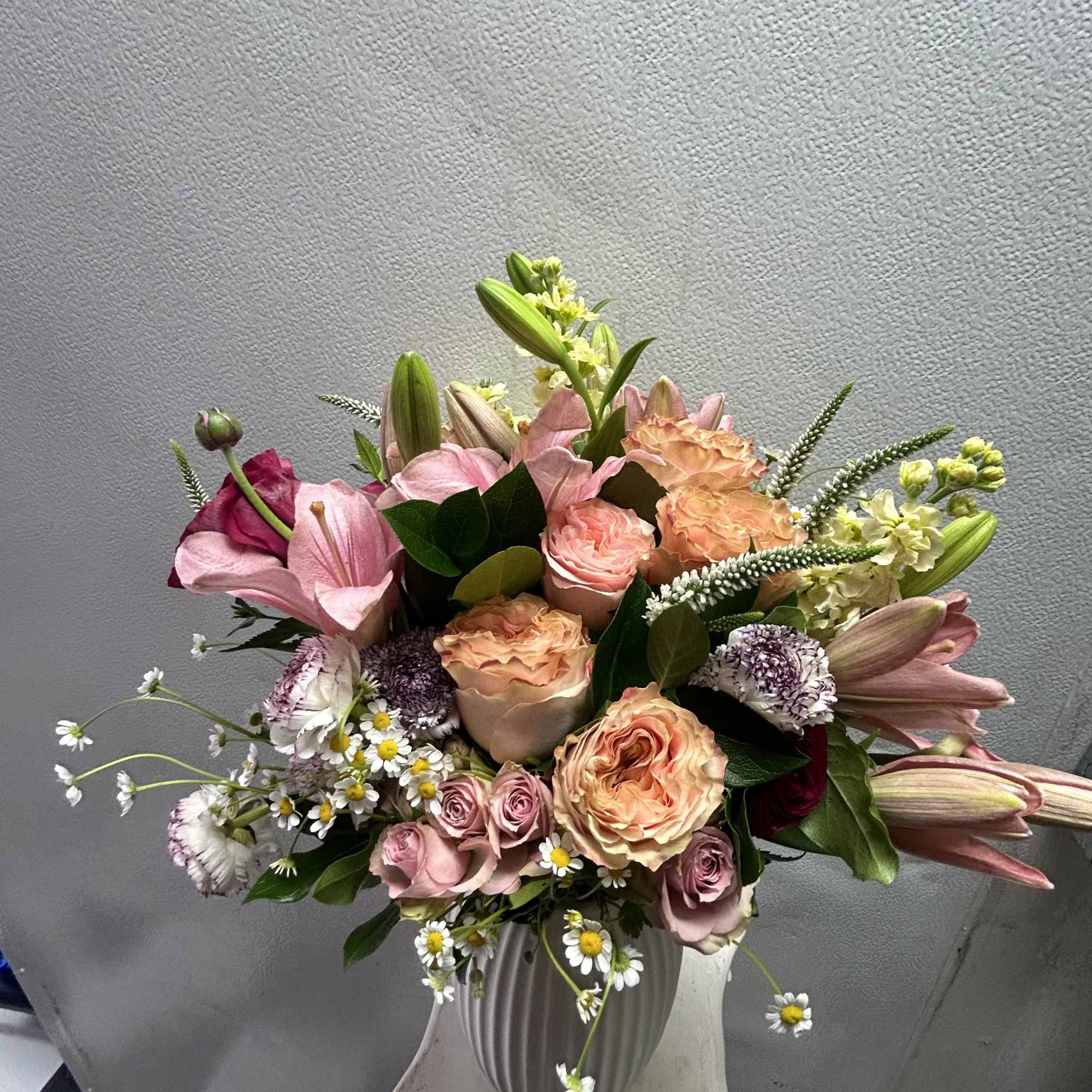 Pink and peach bouquet with lilies and roses in a white vase