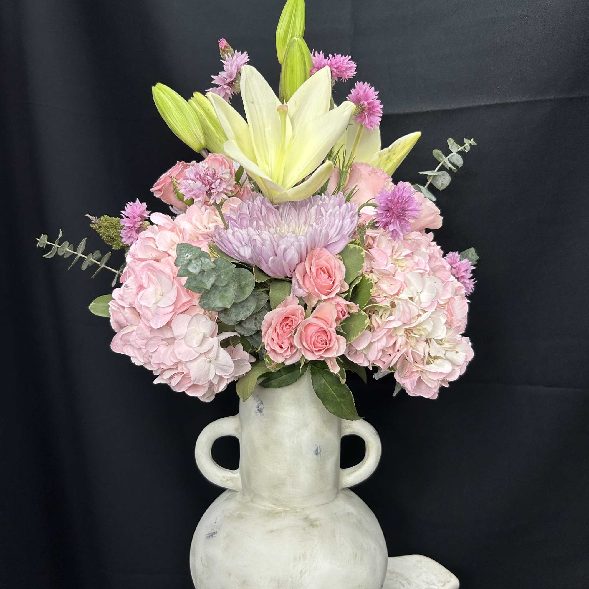 Pink and white floral arrangement in a white vase