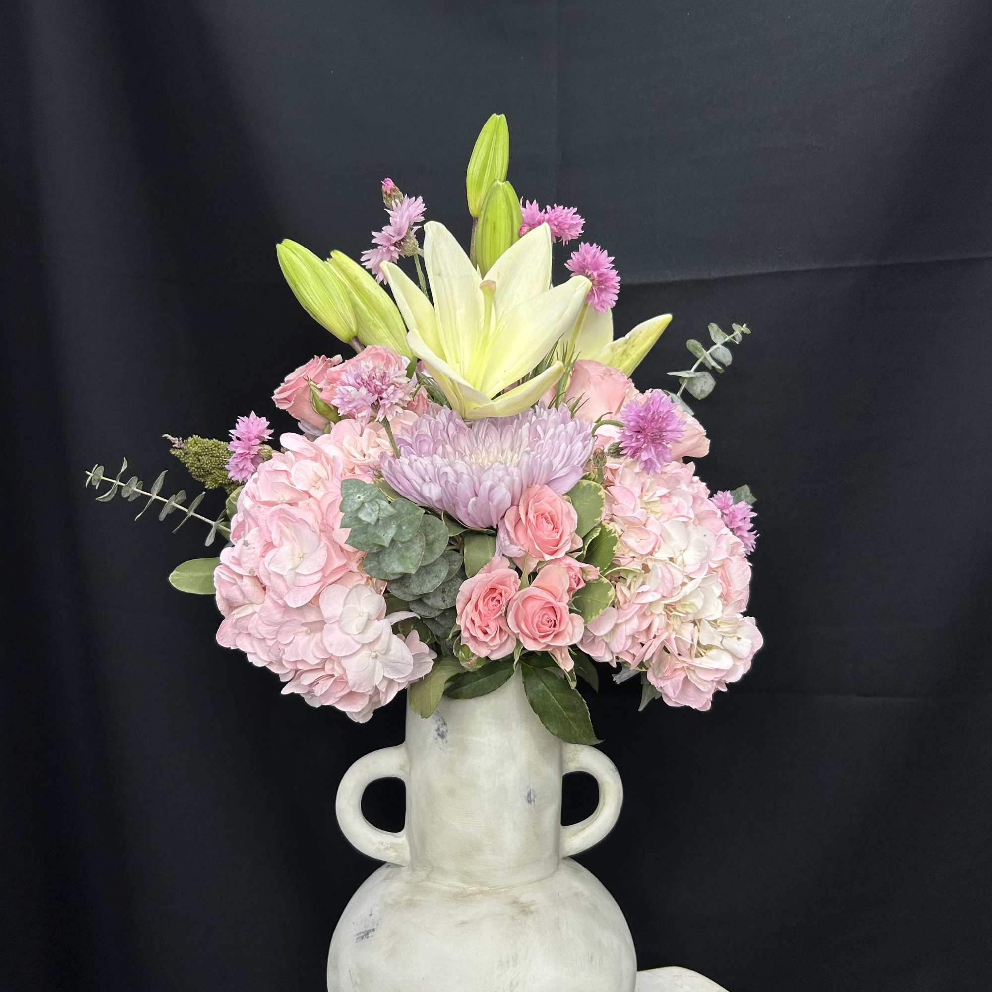 Pink and white floral arrangement in a white vase