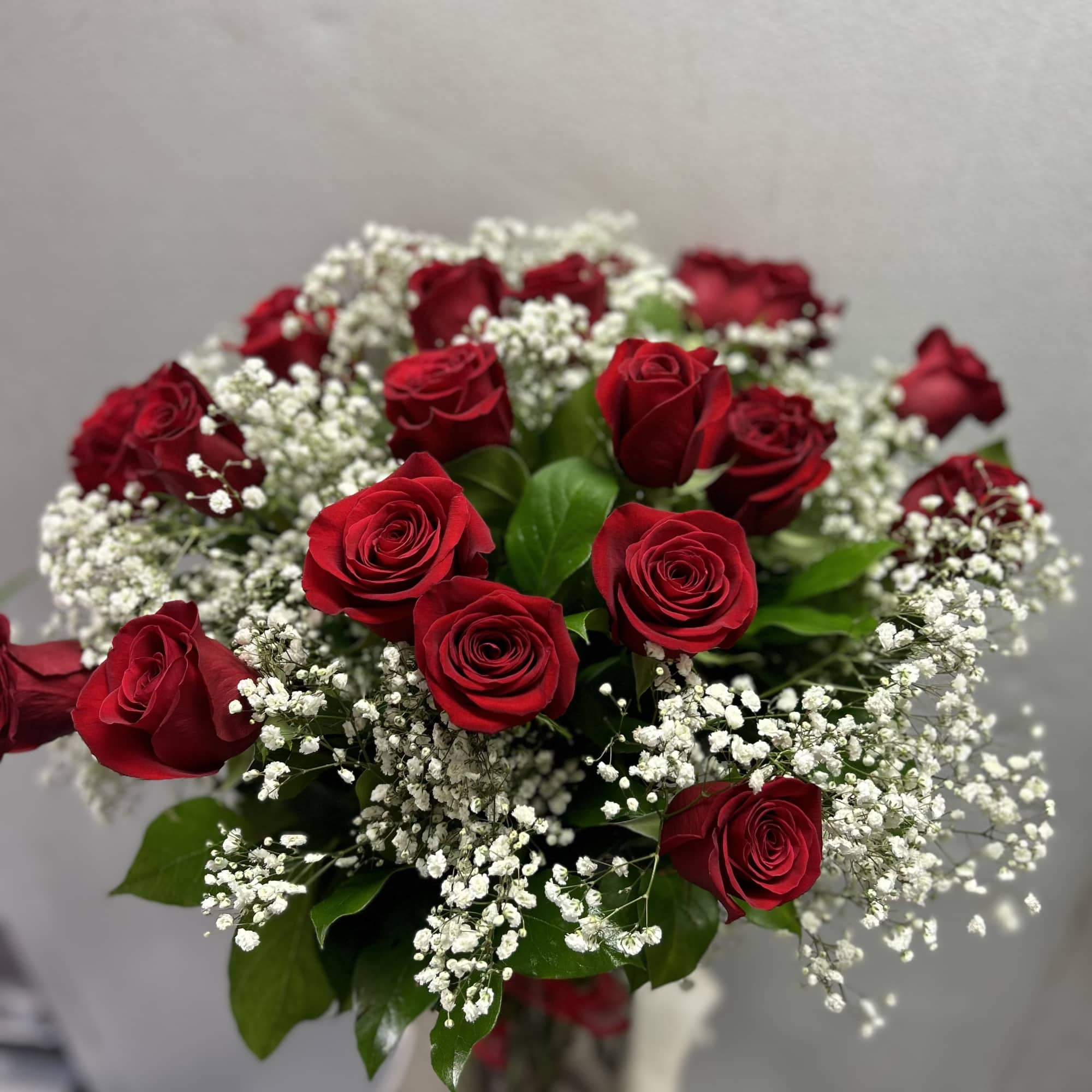 Bouquet of red roses with white baby's breath in a vase