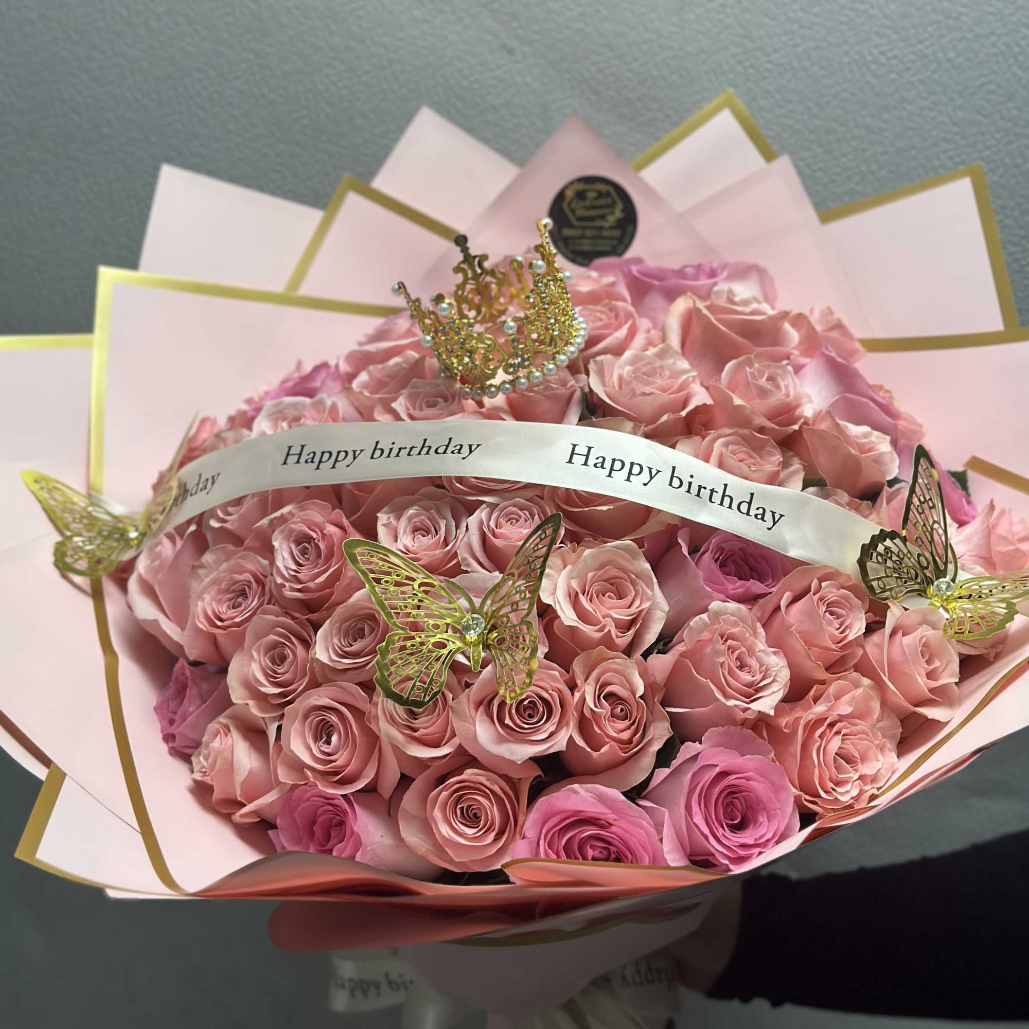 50 roses arranged into a round bouquet with the color paper of