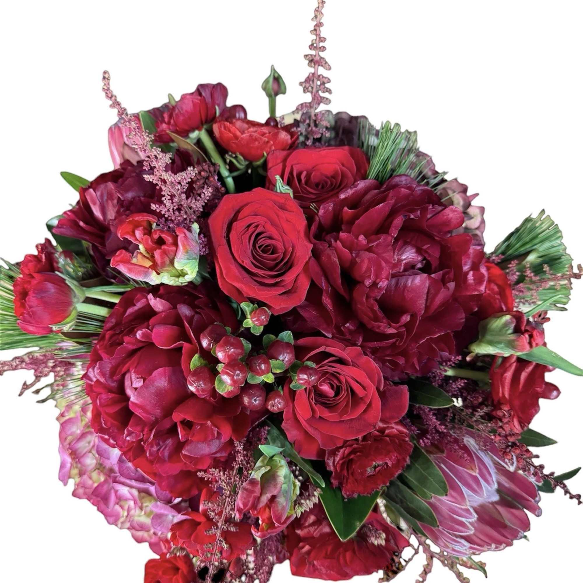 Bouquet of red roses and deep pink blooms with green accents