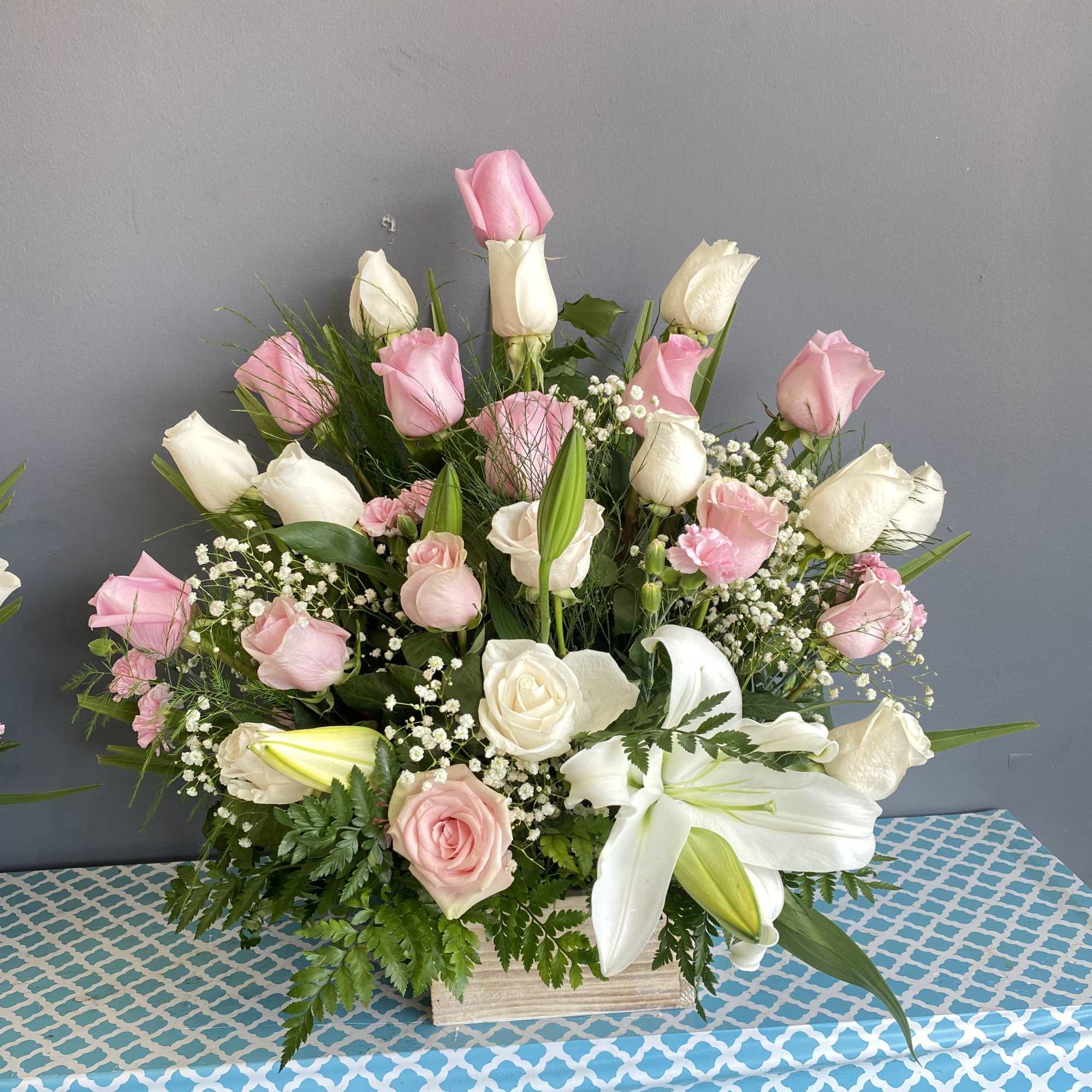 Pink and white roses with lilies in a wooden box arrangement