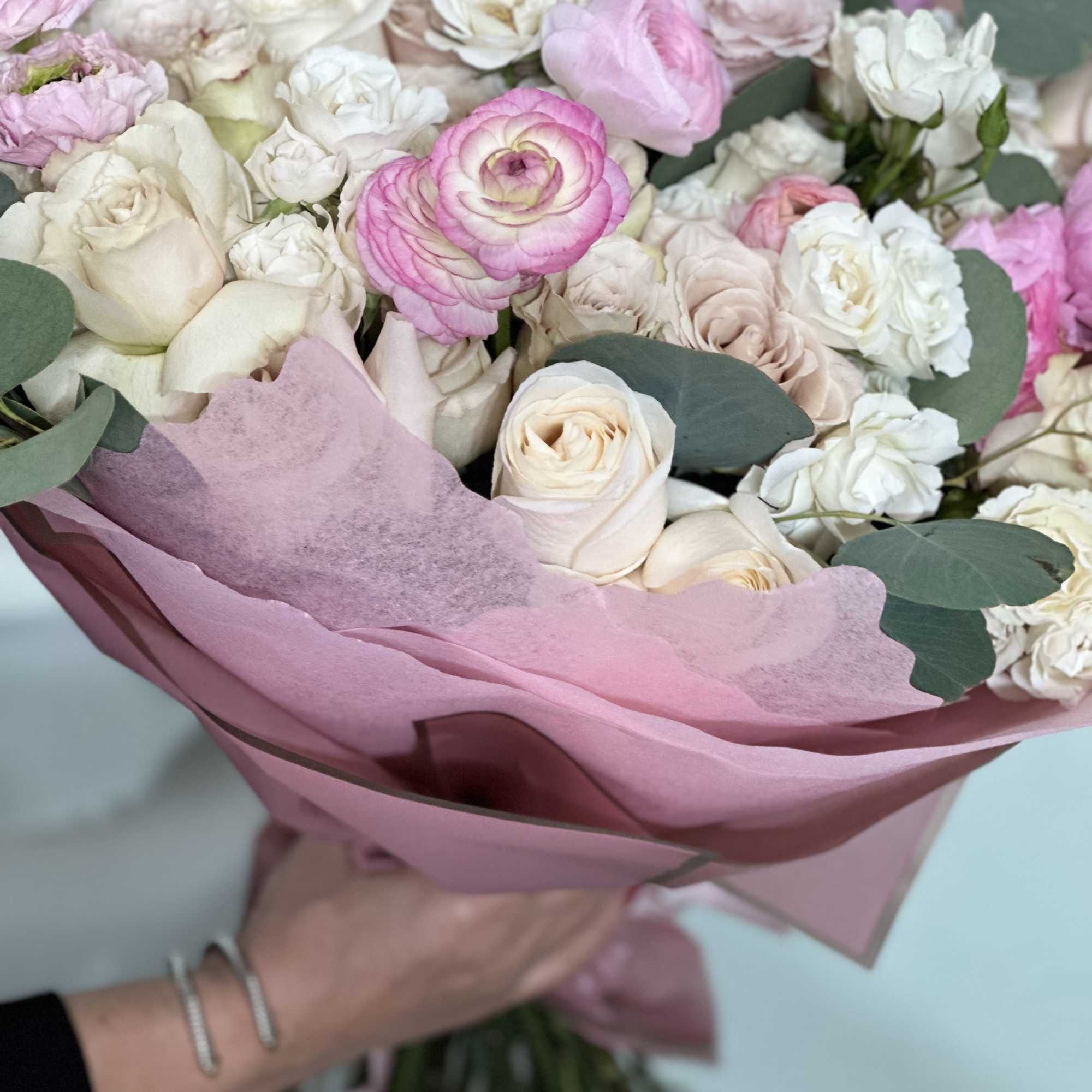 Bouquet of pink and white roses with eucalyptus in pink wrapping