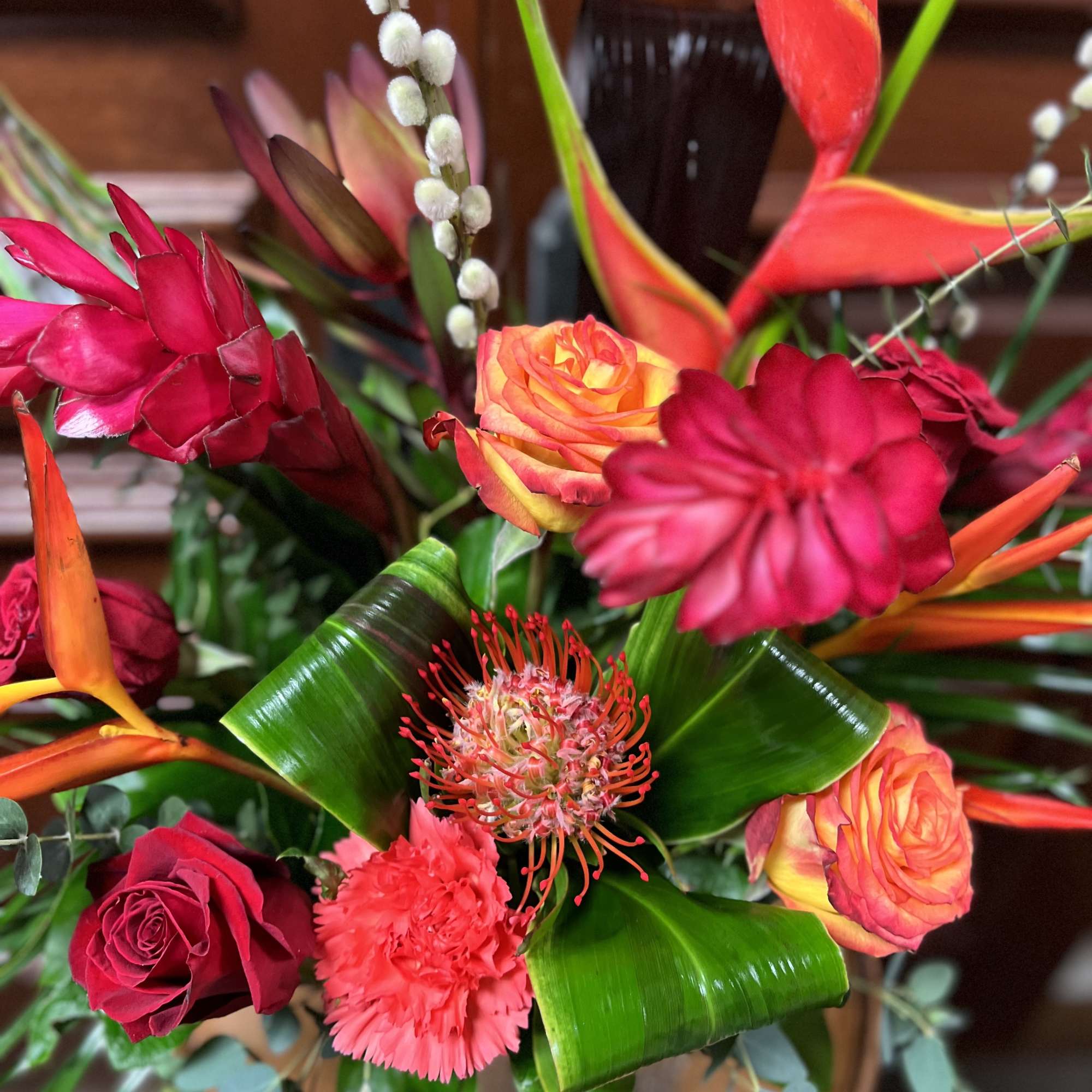 Tropical bouquet with red roses and orange bird-of-paradise flowers
