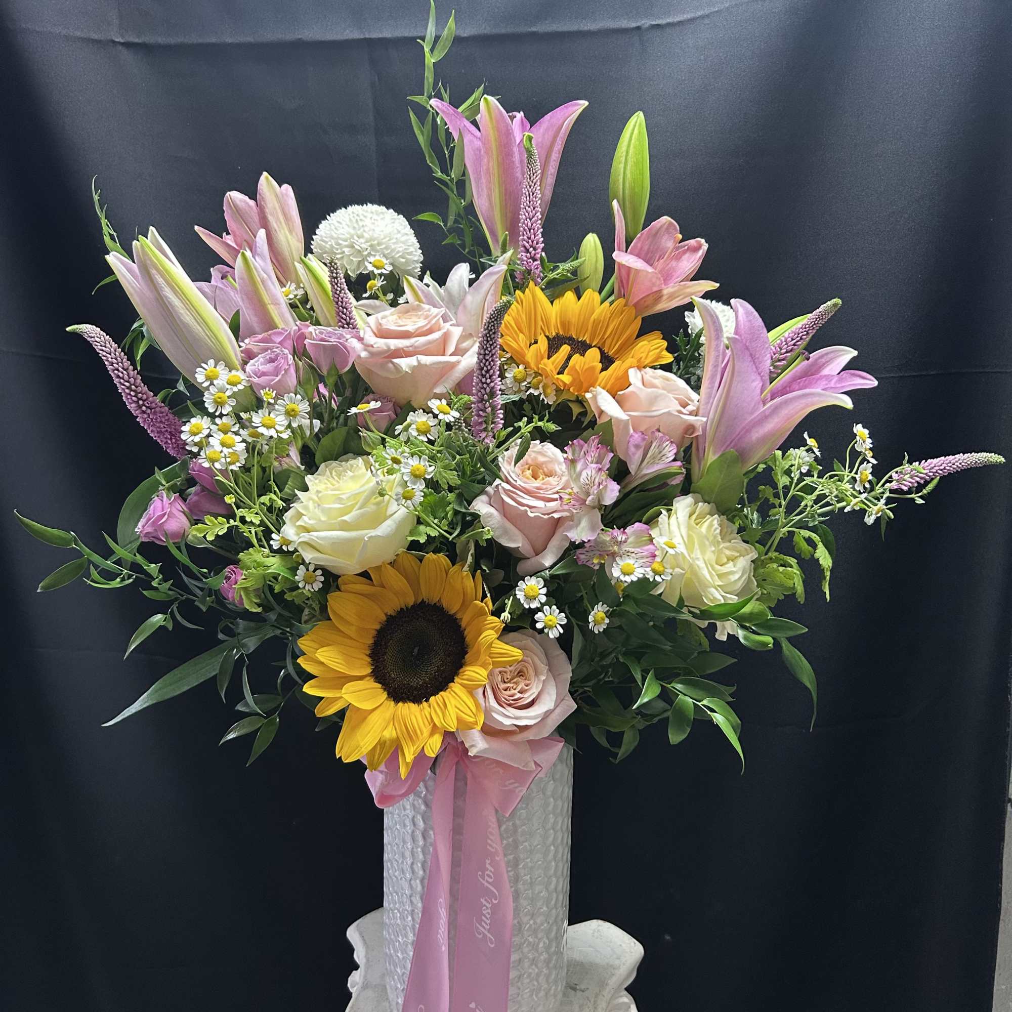 Sun-kissed sunflowers and tall pink lilies give this upright mixed flower arrangement