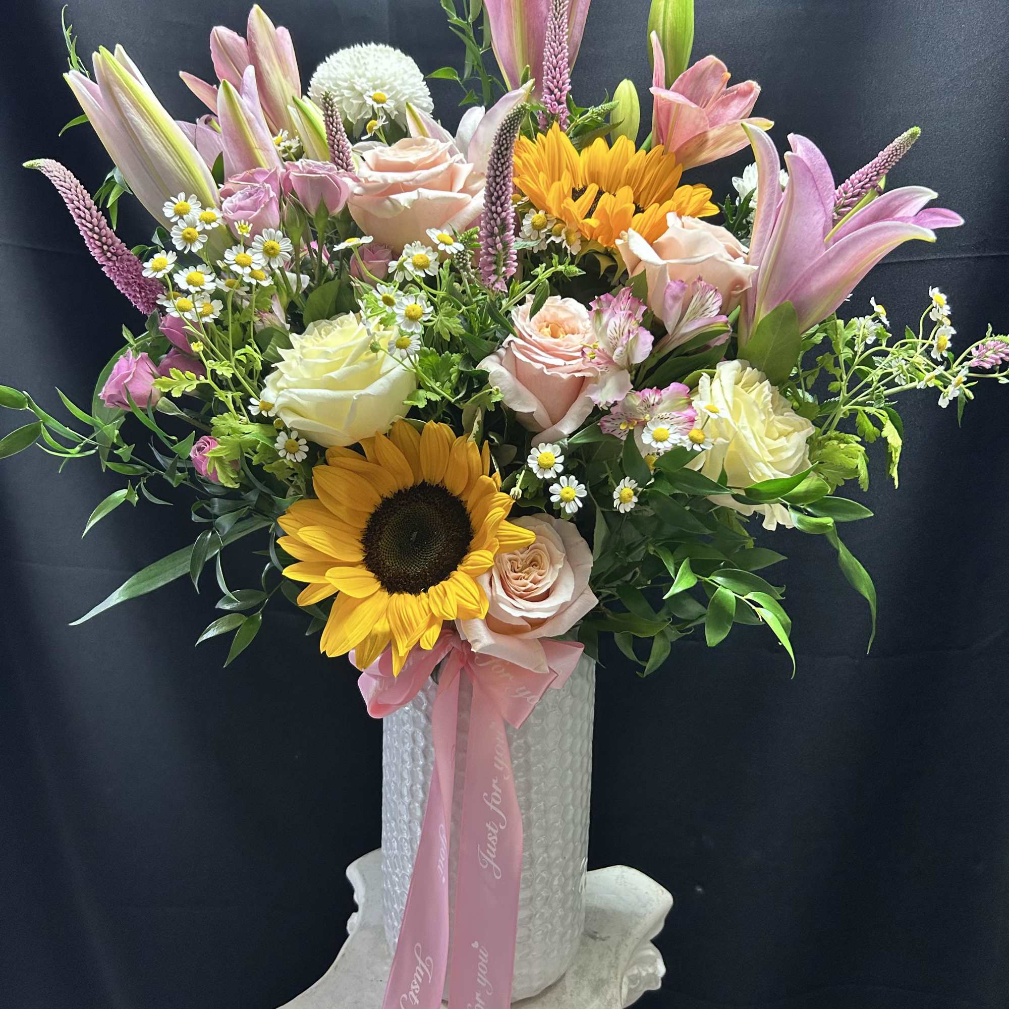 Sun-kissed sunflowers and tall pink lilies give this upright mixed flower arrangement