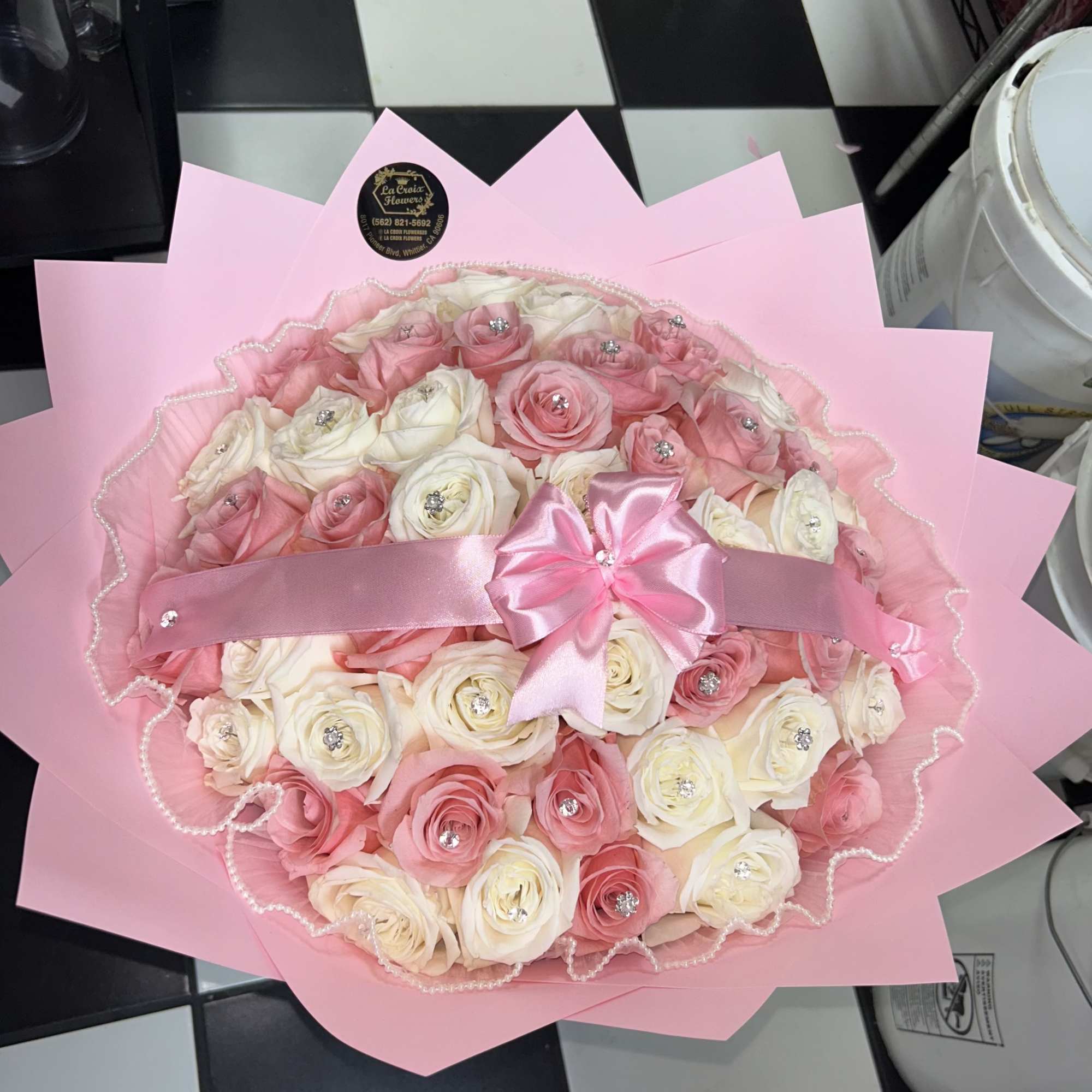 75 roses arranged into a round bouquet with the color paper of